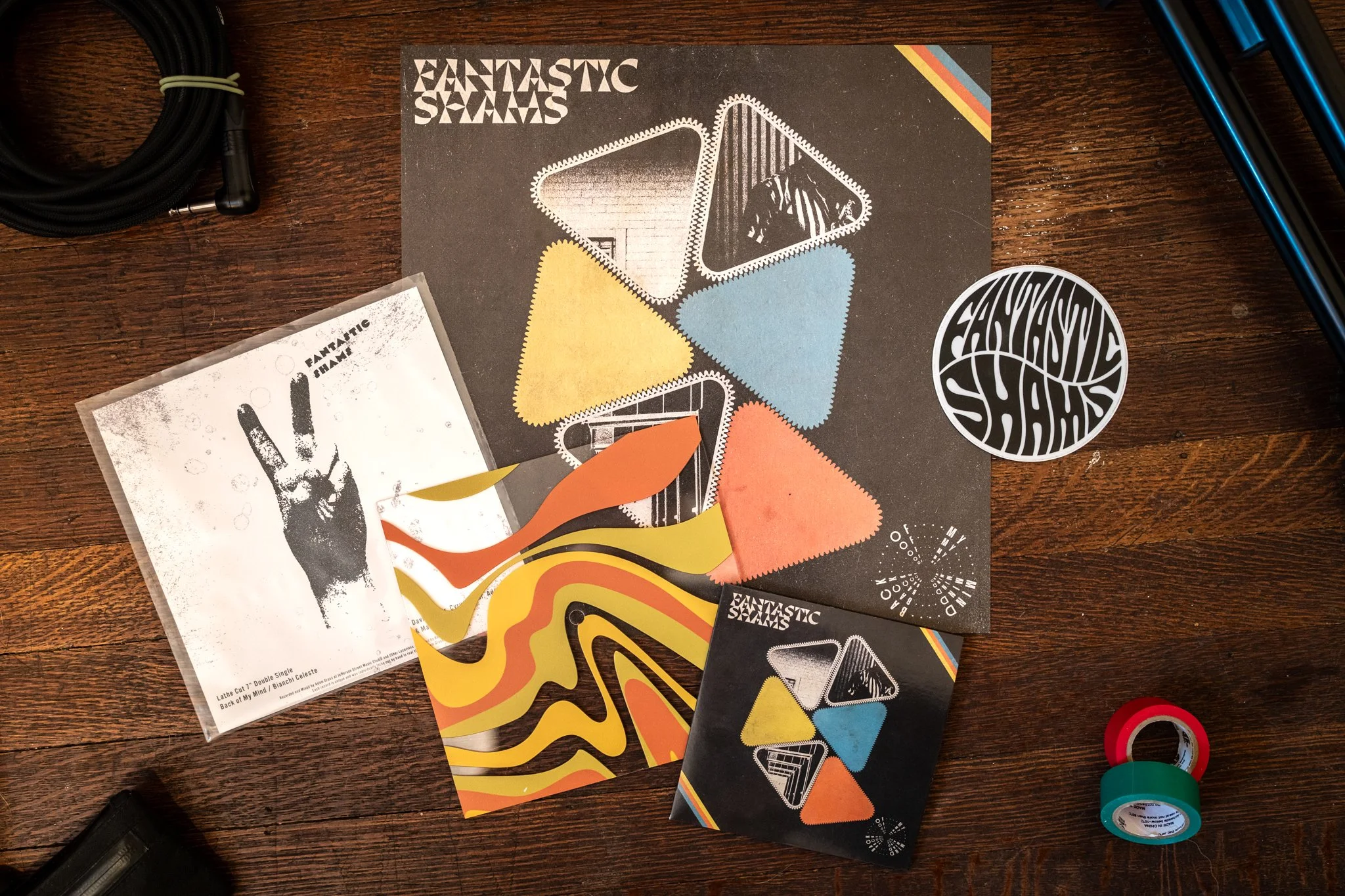 This bundle includes the sophomore Fantastic Shams album Back of My Mind on Compact Disc, a lathe-cut 7" vinyl double single on clear UV printed picture disc featuring the songs "Back of My Mind" and "Bianchi Celest" from the album, as well as a 12"x