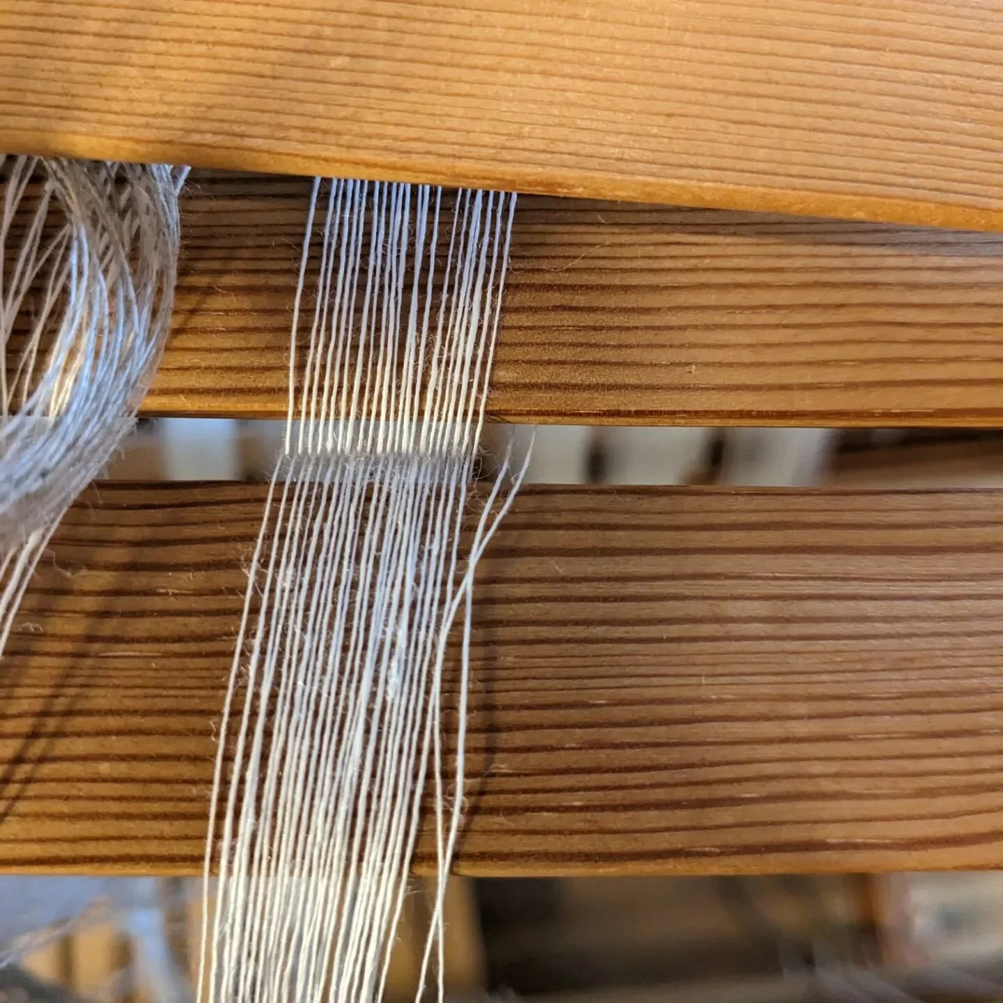 To me, the cross is one of the coolest parts of warping a loom. It gives the threads the memory of the order they were wound in - they carry that information themselves all the way through the warping process. 

This here is an imperfect cross; becau