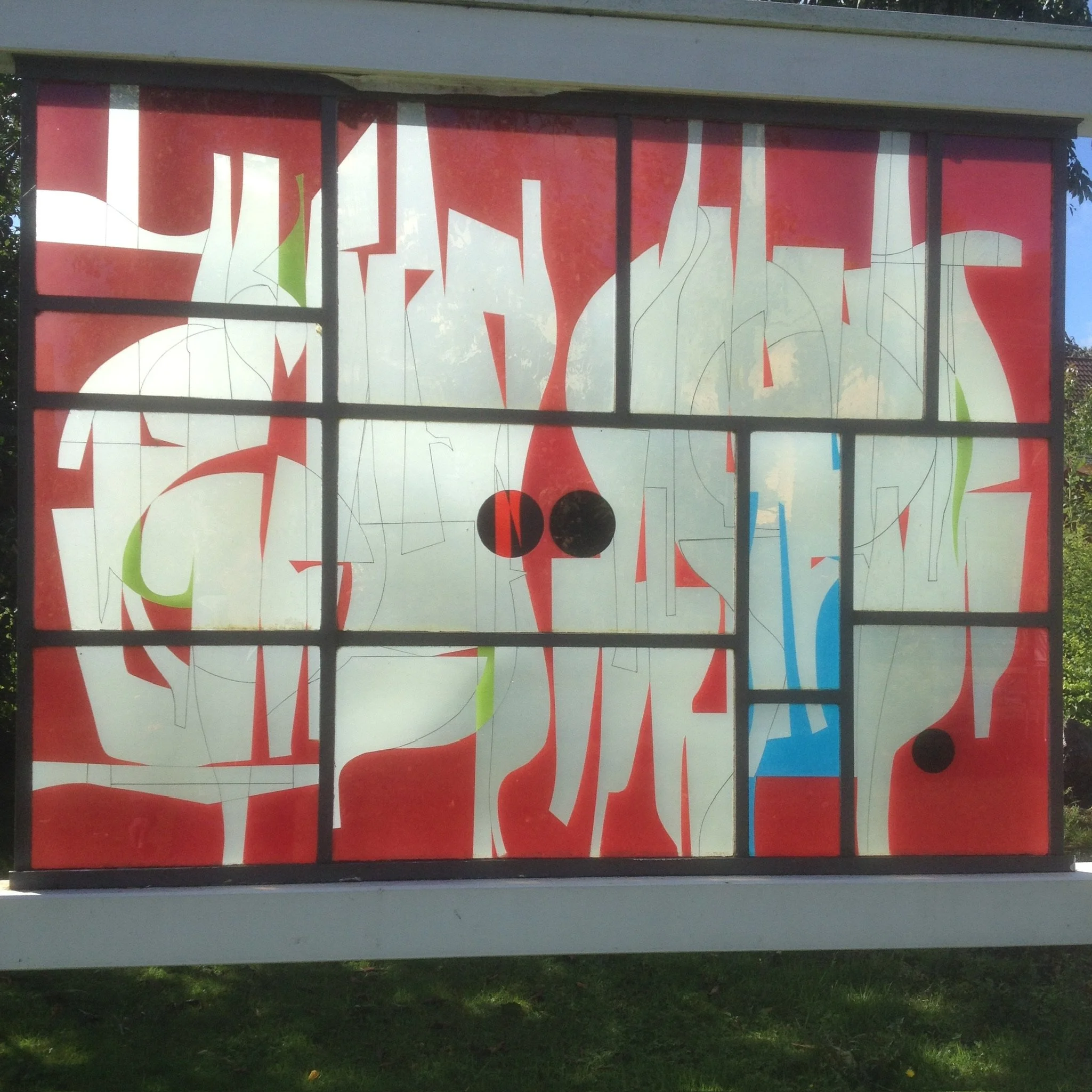 Buntglasfenster im abstrakten Stil/Opal, Opak / UV Klebuni. mit roten, weißen und blauen Elementen.