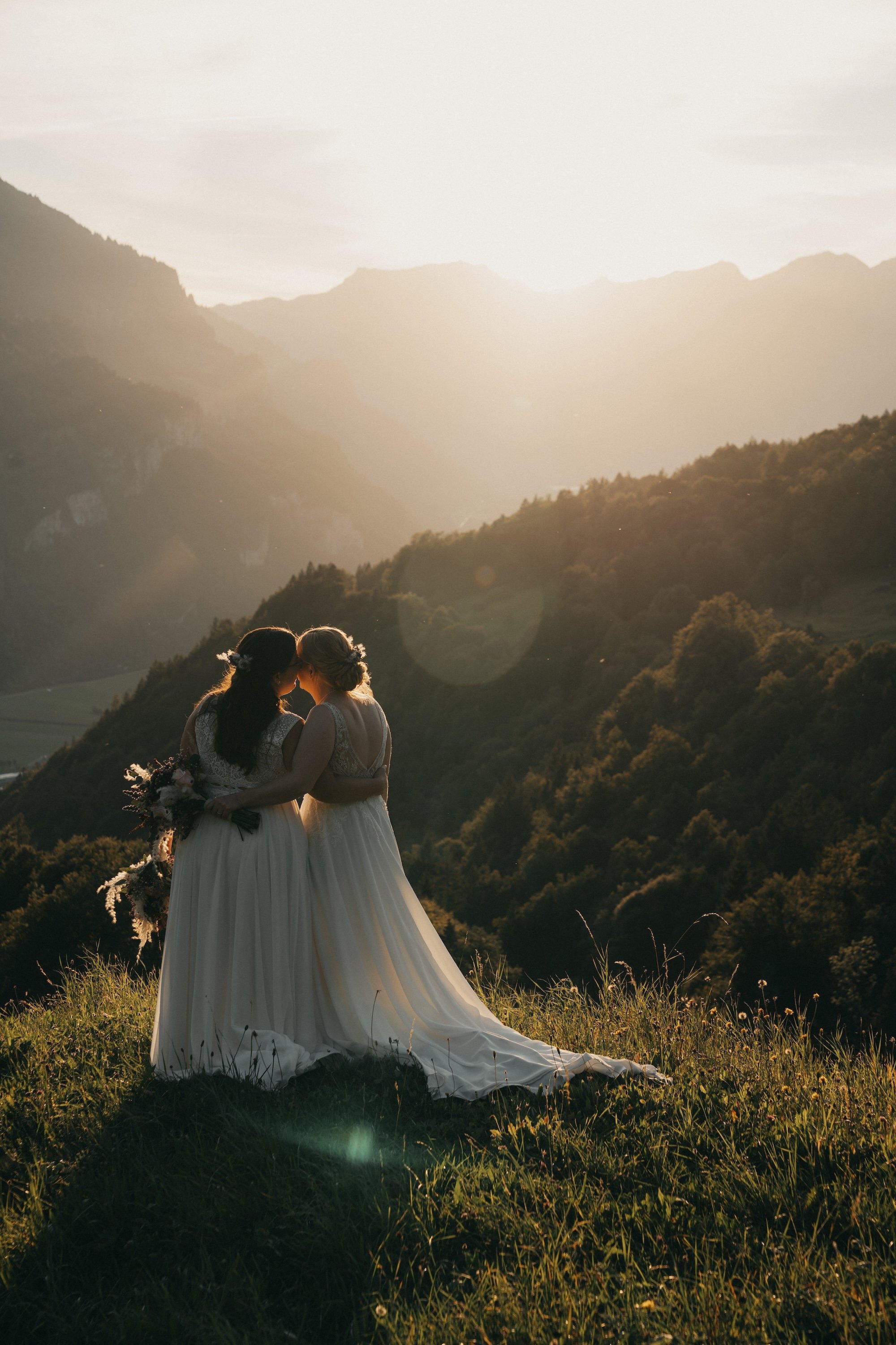 Ein inniger Moment von Nadine und Svenja im goldenen Licht der Schweizer Berge.