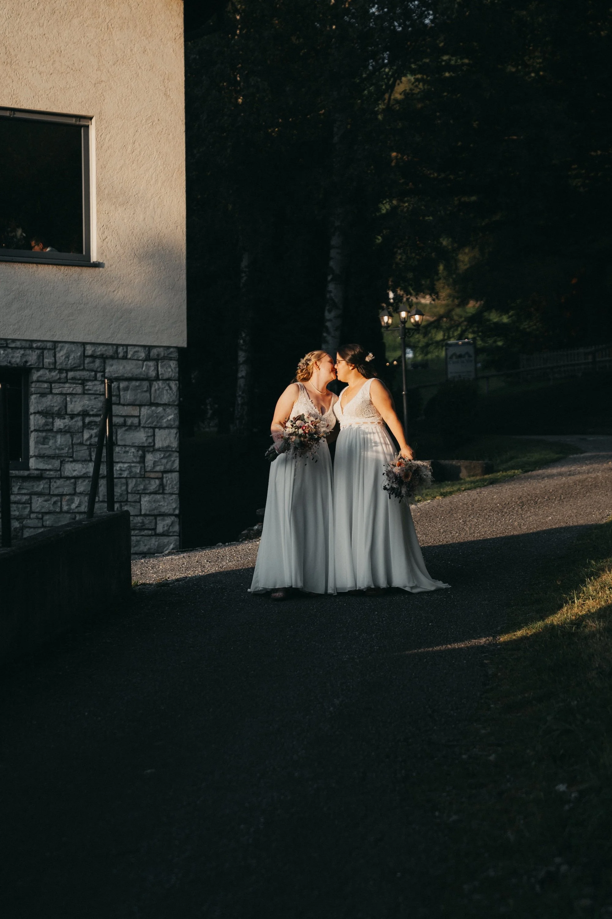 Nadine und Svenja küssen sich im Abendlicht – queere Hochzeit im Berner Oberland.