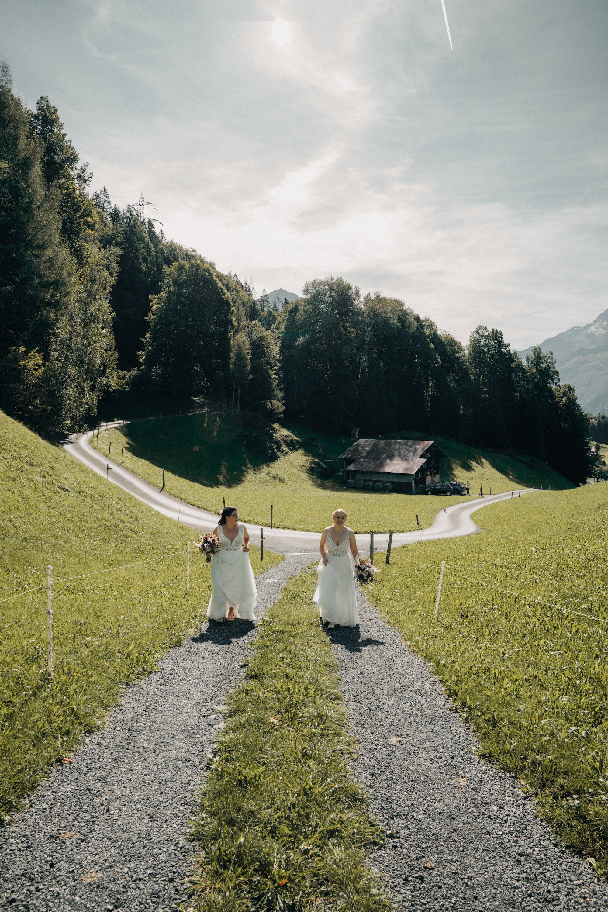 Zwei Bräute auf dem Weg durch die Berglandschaft des Haslibergs – Hochzeitsfotografie im Berner Oberland.