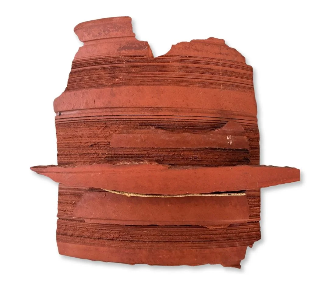 Stack of red clay bricks with some broken pieces.