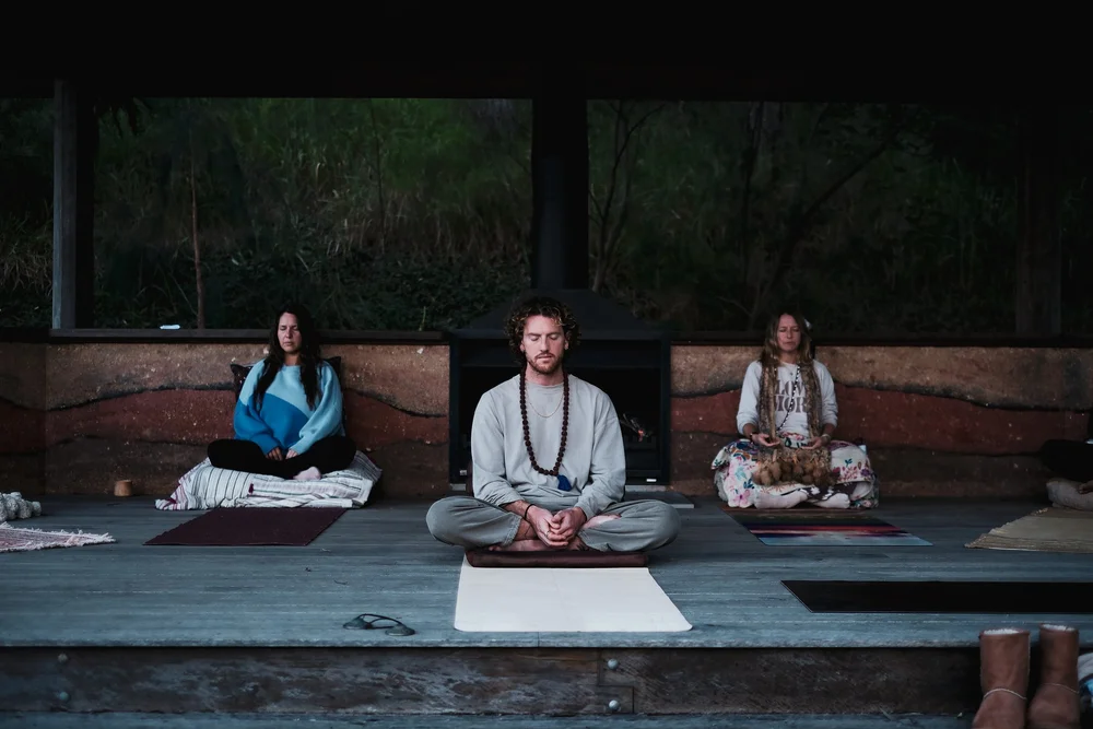 Mike Watts leading a group Vedic Meditation on a deck