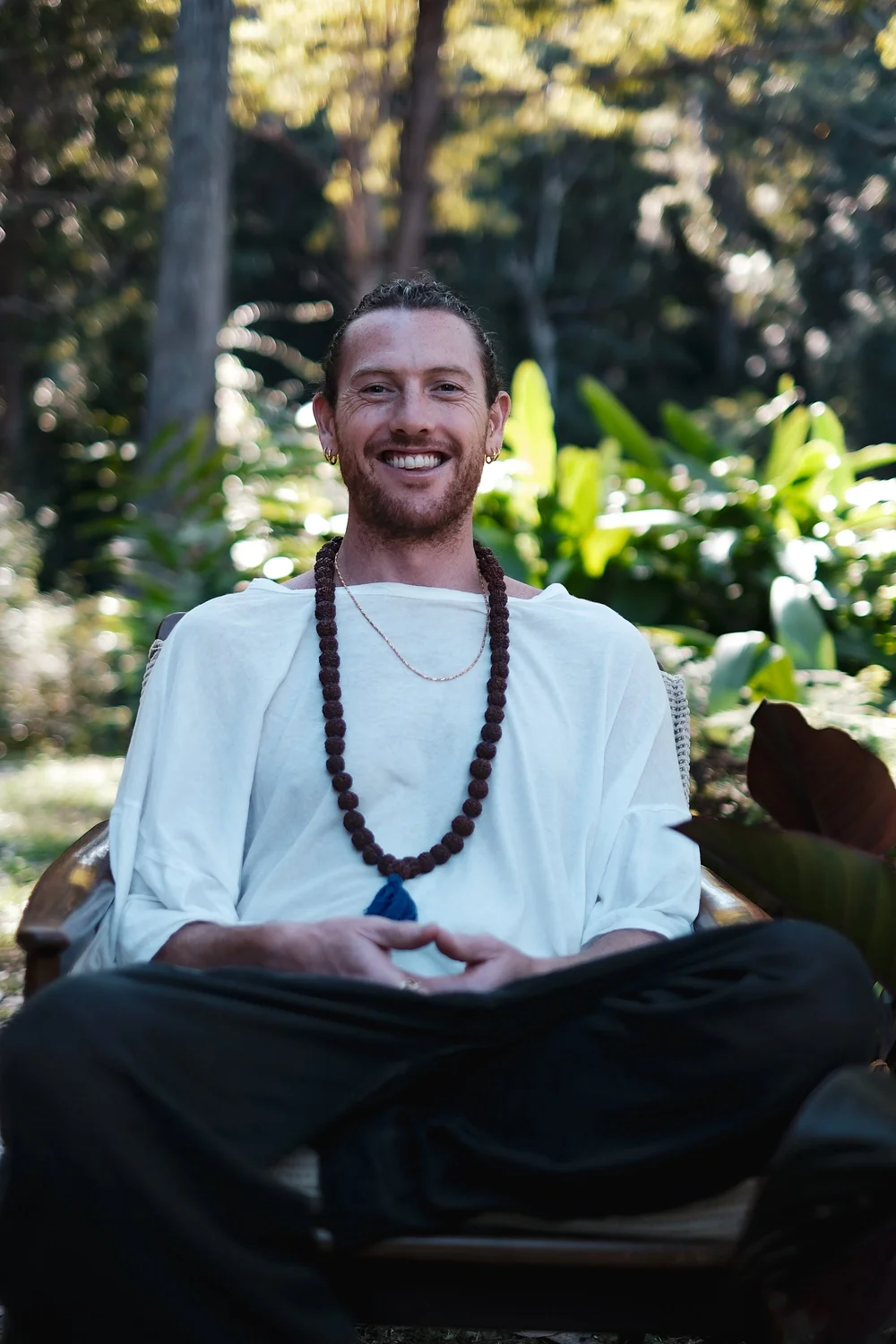 Mike Watts, Vedic Meditation teacher, sitting in a garden in Bali