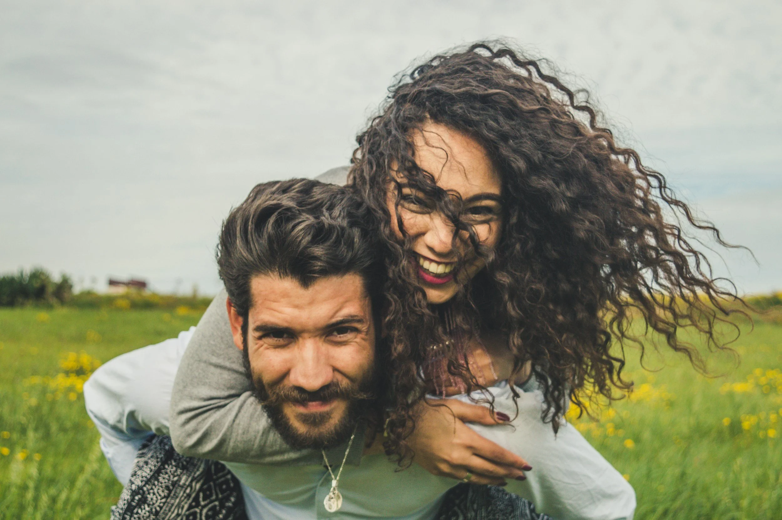 Husband gives wife a piggy back ride.  They are more happy because they got marriage therapy with a marriage counselor at Fortis therapy group in Leavenworth, KS who also offers couples counseling in Liberty, MO