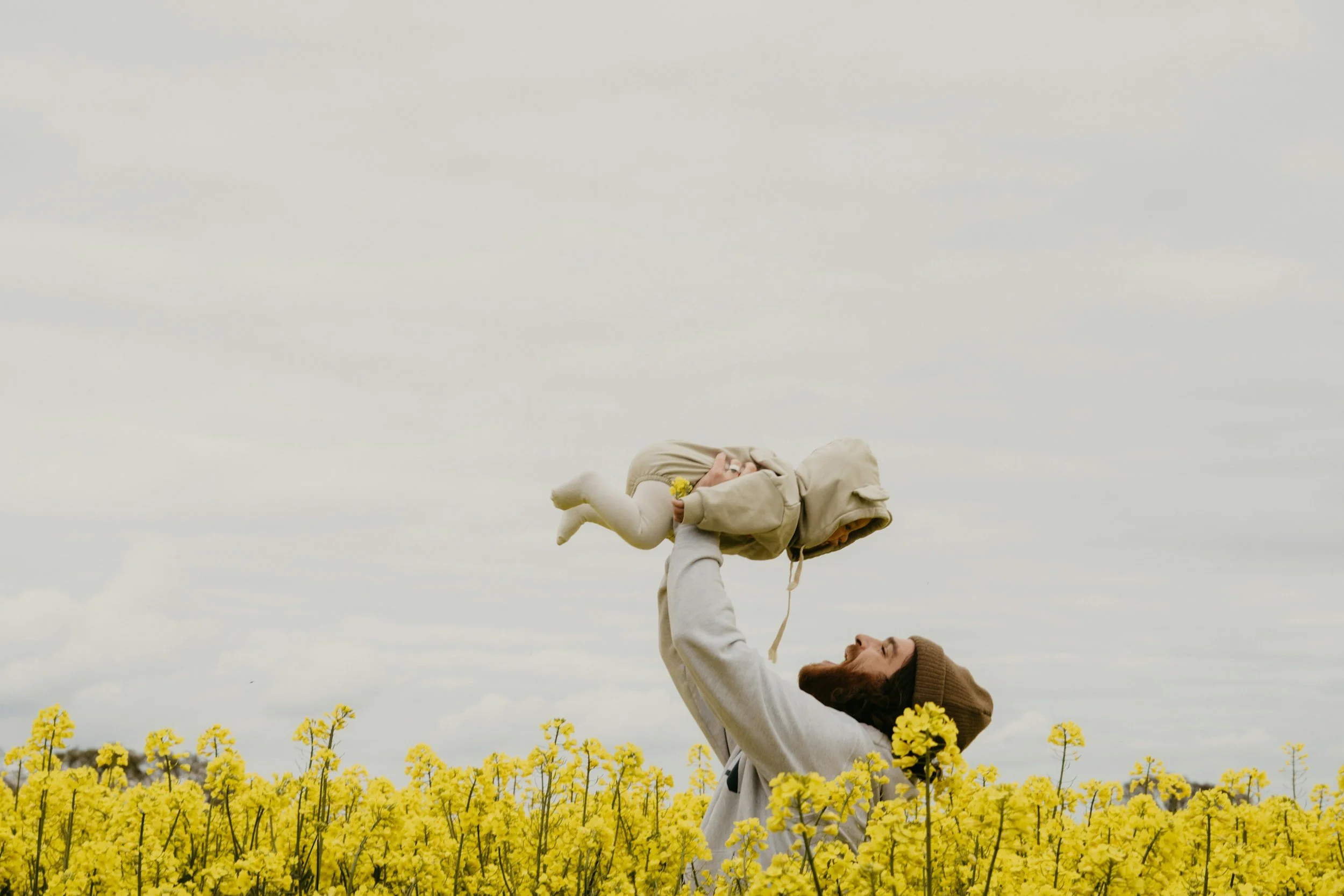 Dad and toddler play in the field because dad knows how to use emotional regulation from seeing an online therapist in Ottawa, KS with Fortis counseling center.