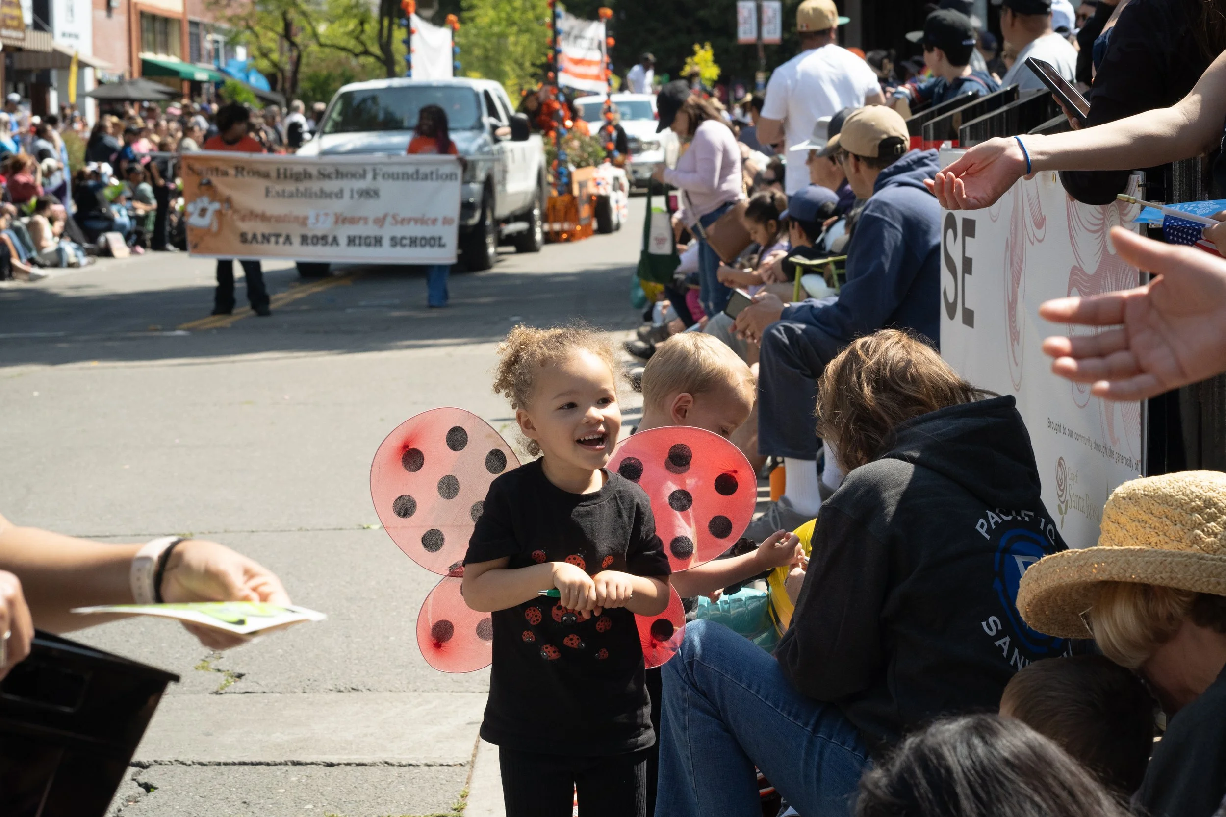 A little girl in ladybug wings watches the annual Rose Parade in Santa Rosa. Coverage for the Press Democrat.