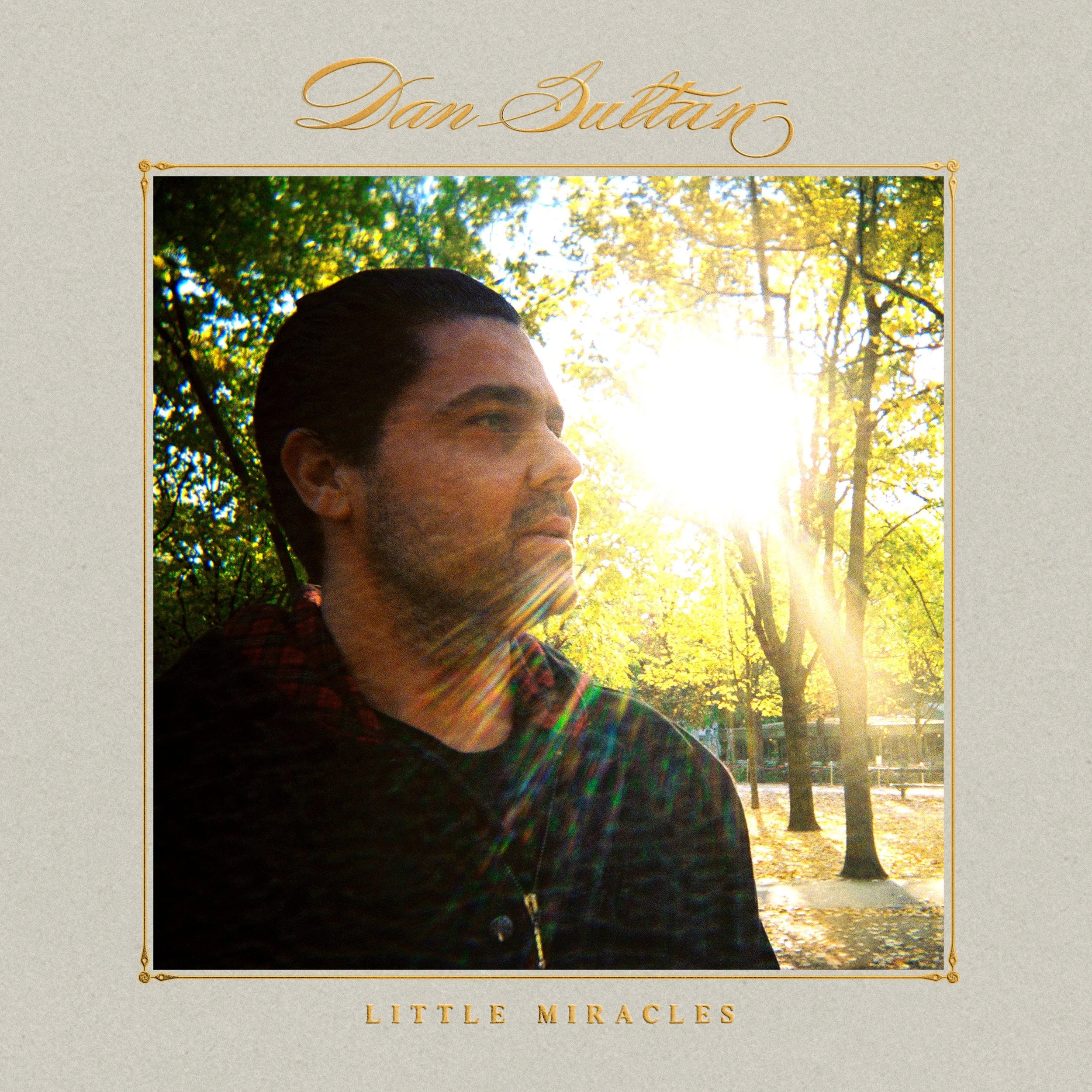 Dan Sultan Little Miracles album cover art featuring a profile portrait of the musician in a sunlit park with bright golden lens flare.