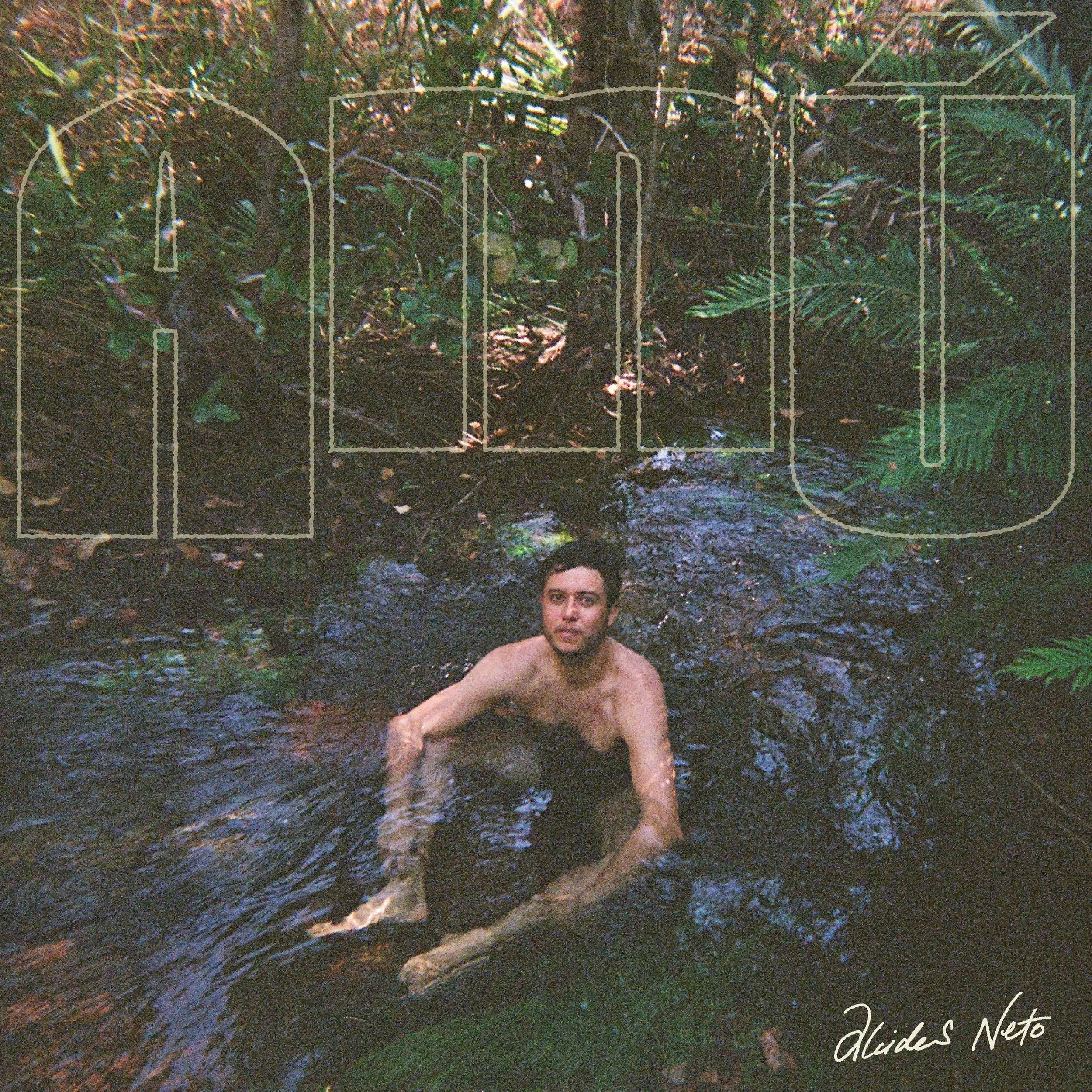 Album cover for Alcides Neto's "Amū" featuring the artist sitting in a forest stream. Textured, grainy aesthetic with large outlined title text.