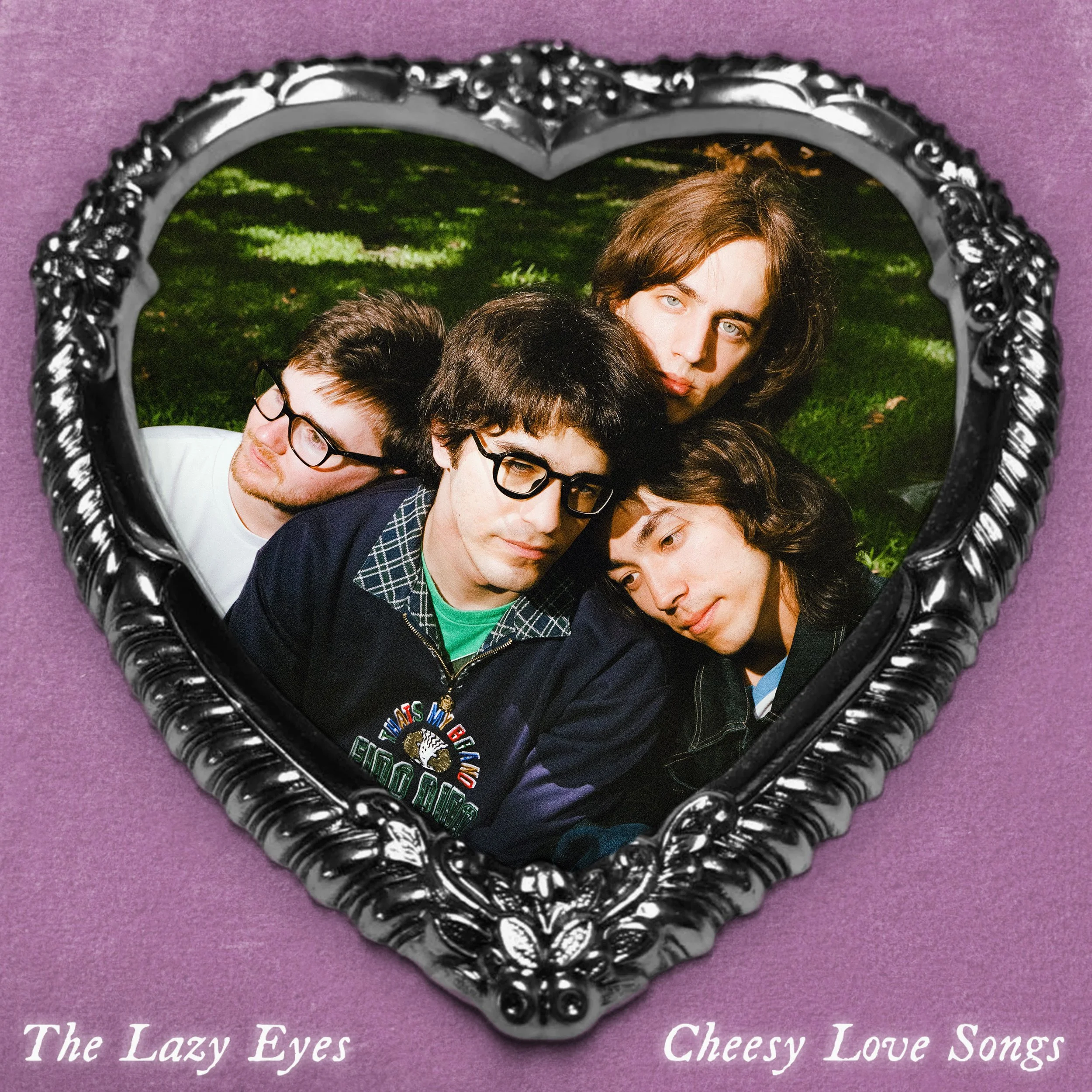 The Lazy Eyes Cheesy Love Songs album cover. Band members in a silver heart-shaped frame on a purple background. Psychedelic rock music artwork.