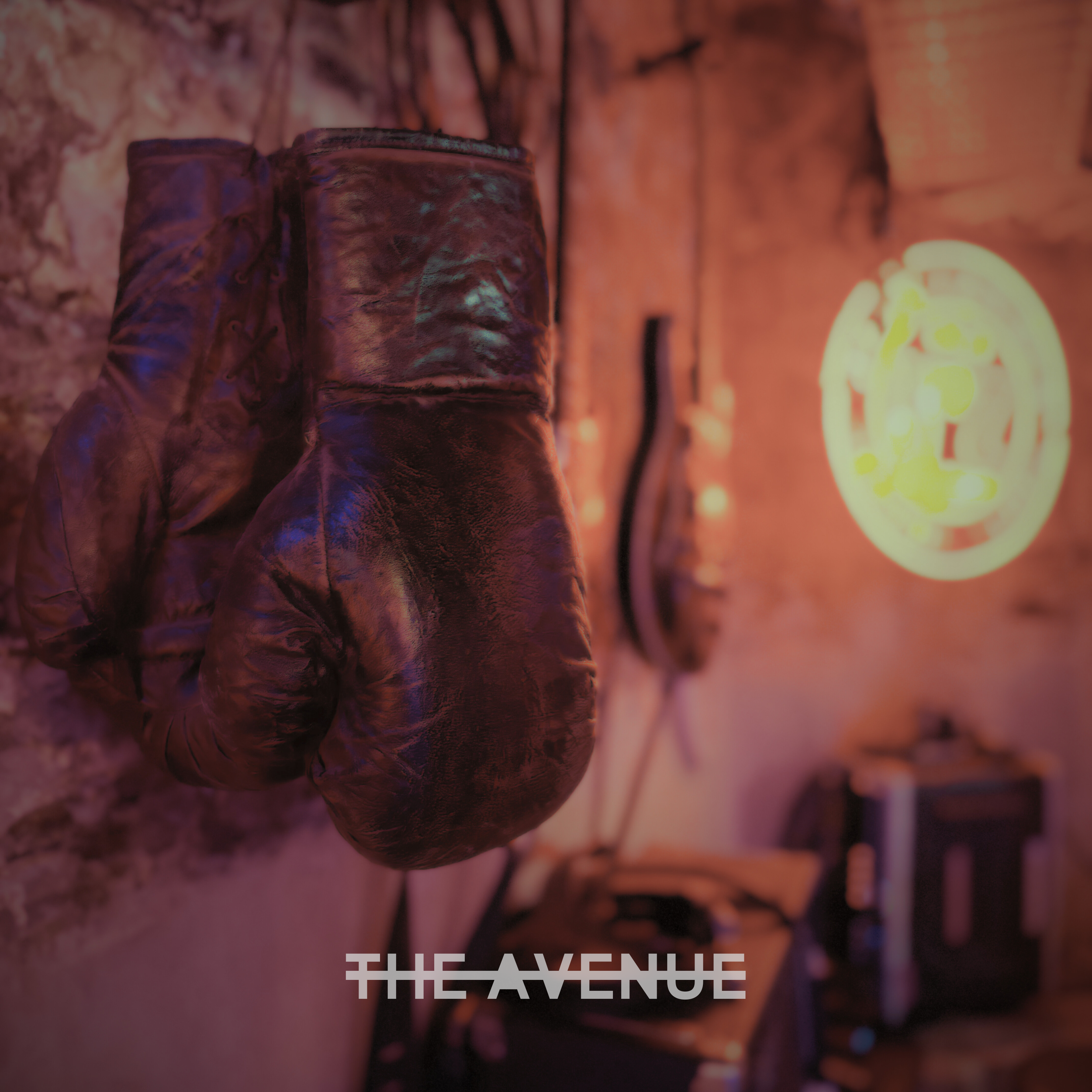 Indiago 'The Avenue' single cover art. An abandoned house at sunset with vibrant orange and purple lighting. Indie rock band from Adelaide, 2026.