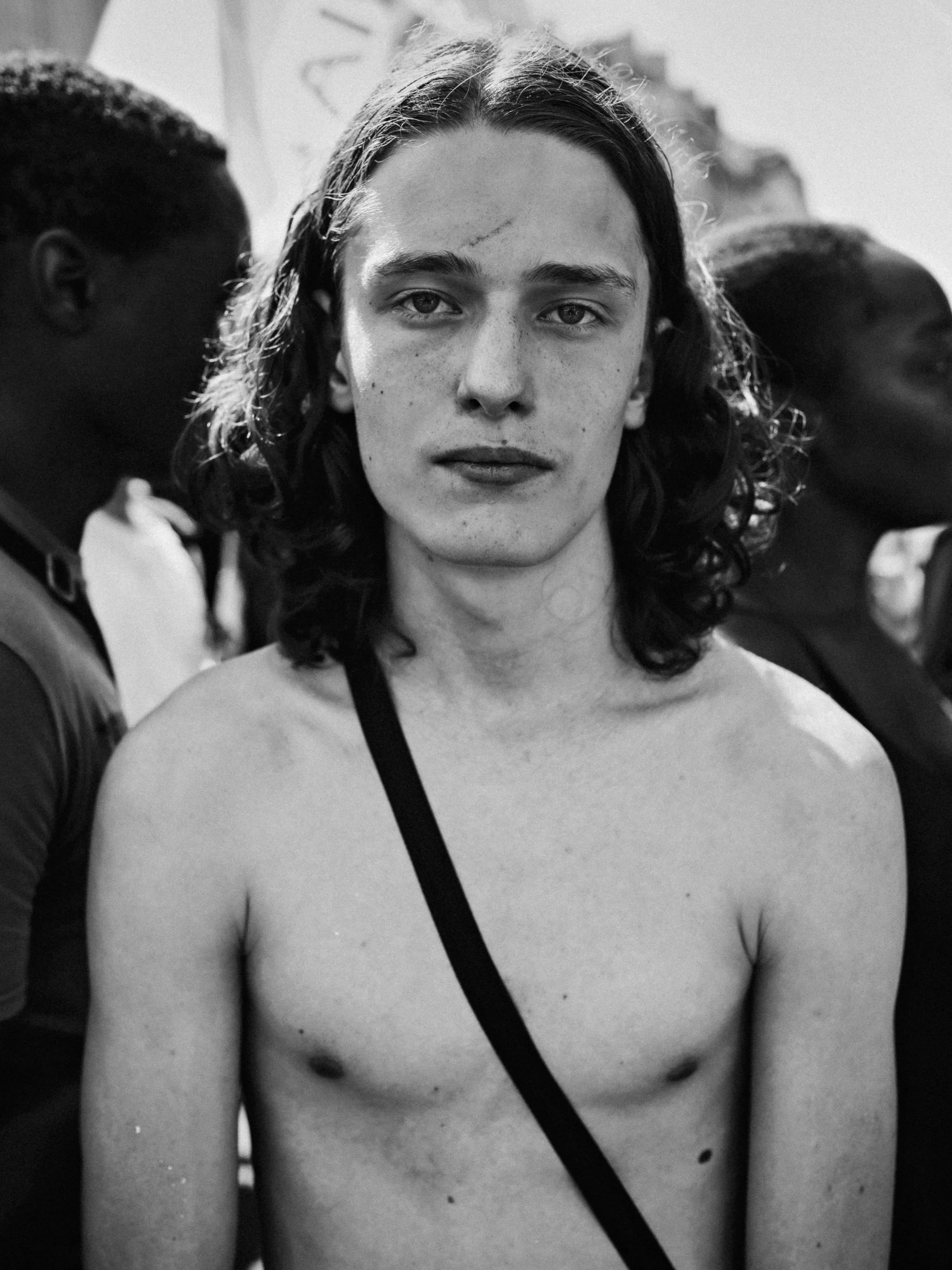 Black and white photograph of a young male body exposed in urban space, from the series FRICTION by Lulu La Falaise.