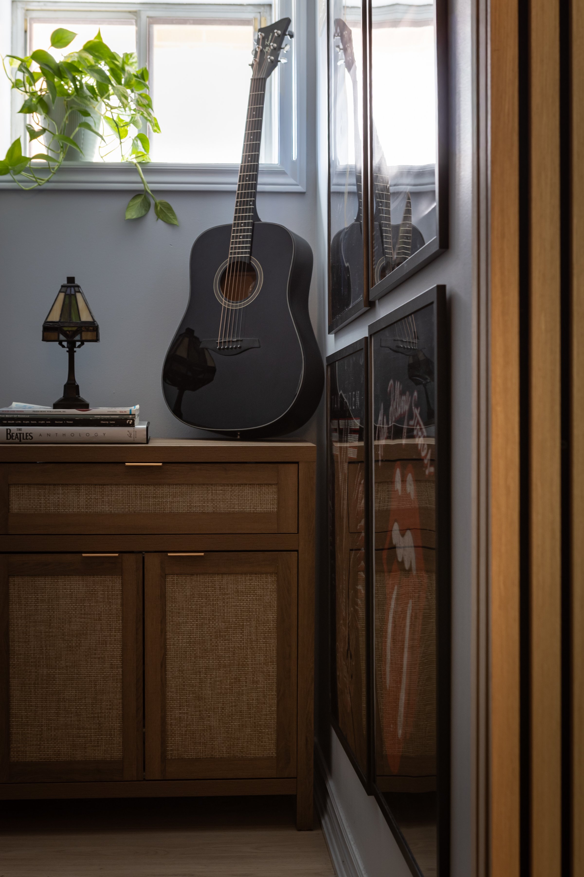 Music nook featuring guitar, framed music posters, and vintage style cabinet in Toronto Ontario, Project Ten Forward by Inspired Spaces Design Studio