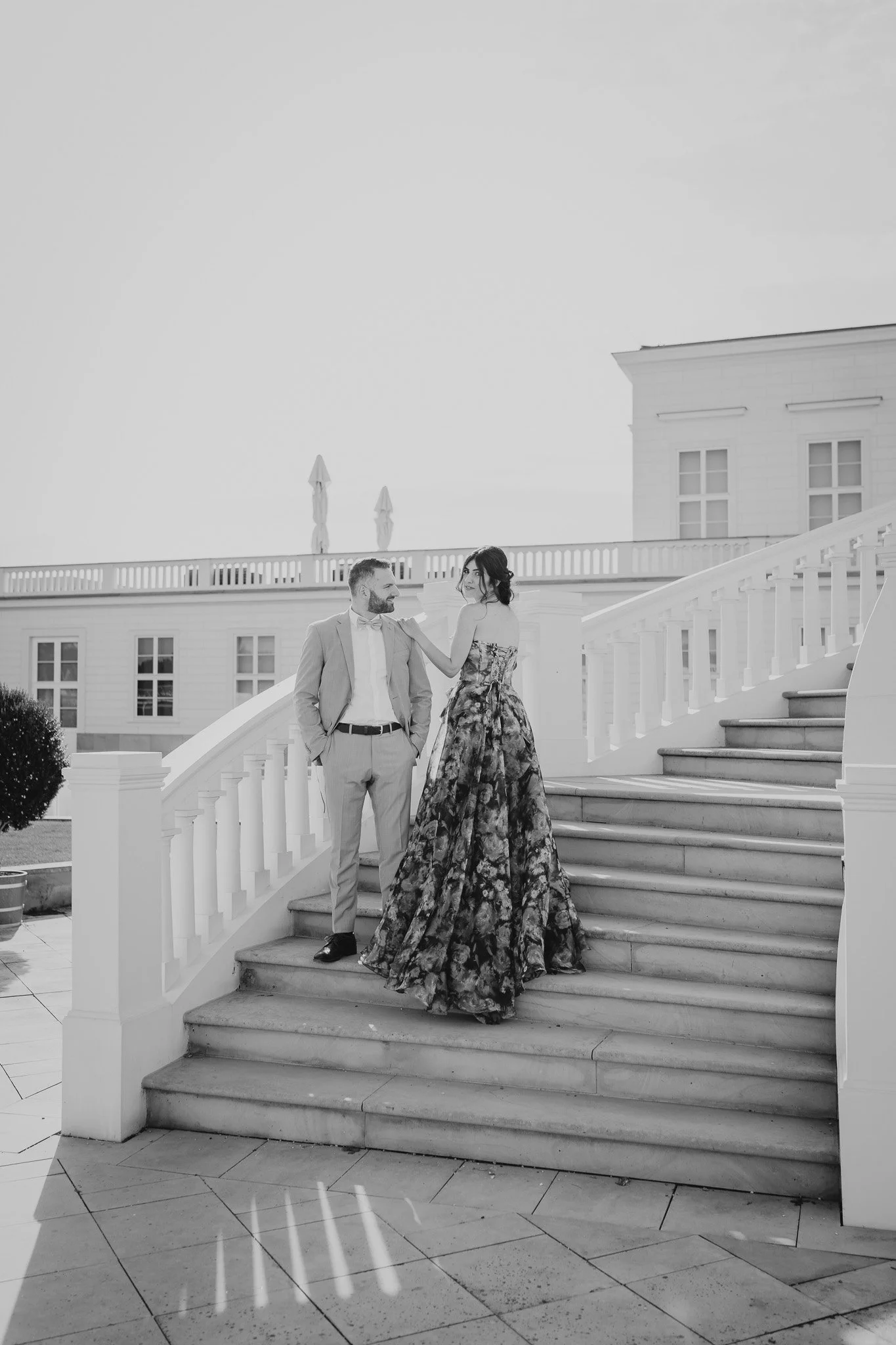Ein verlobtes Paar steht auf der Treppe der Orangerie in Hannover den Herrenhäuser Gärten