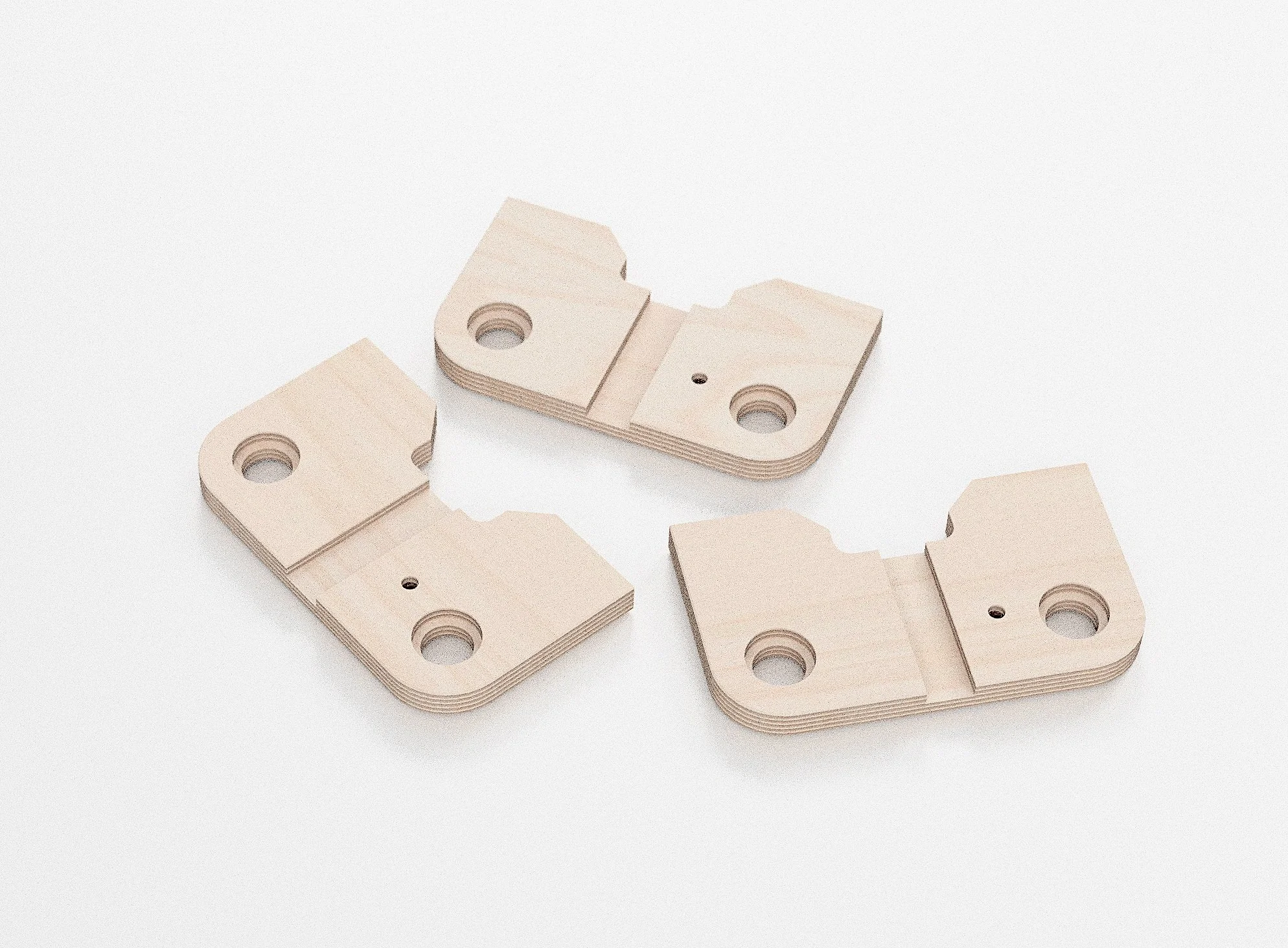 Ensemble de trois pièces en bois découpé et empilé, avec des trous et des segments découpés, placé sur un fond blanc.