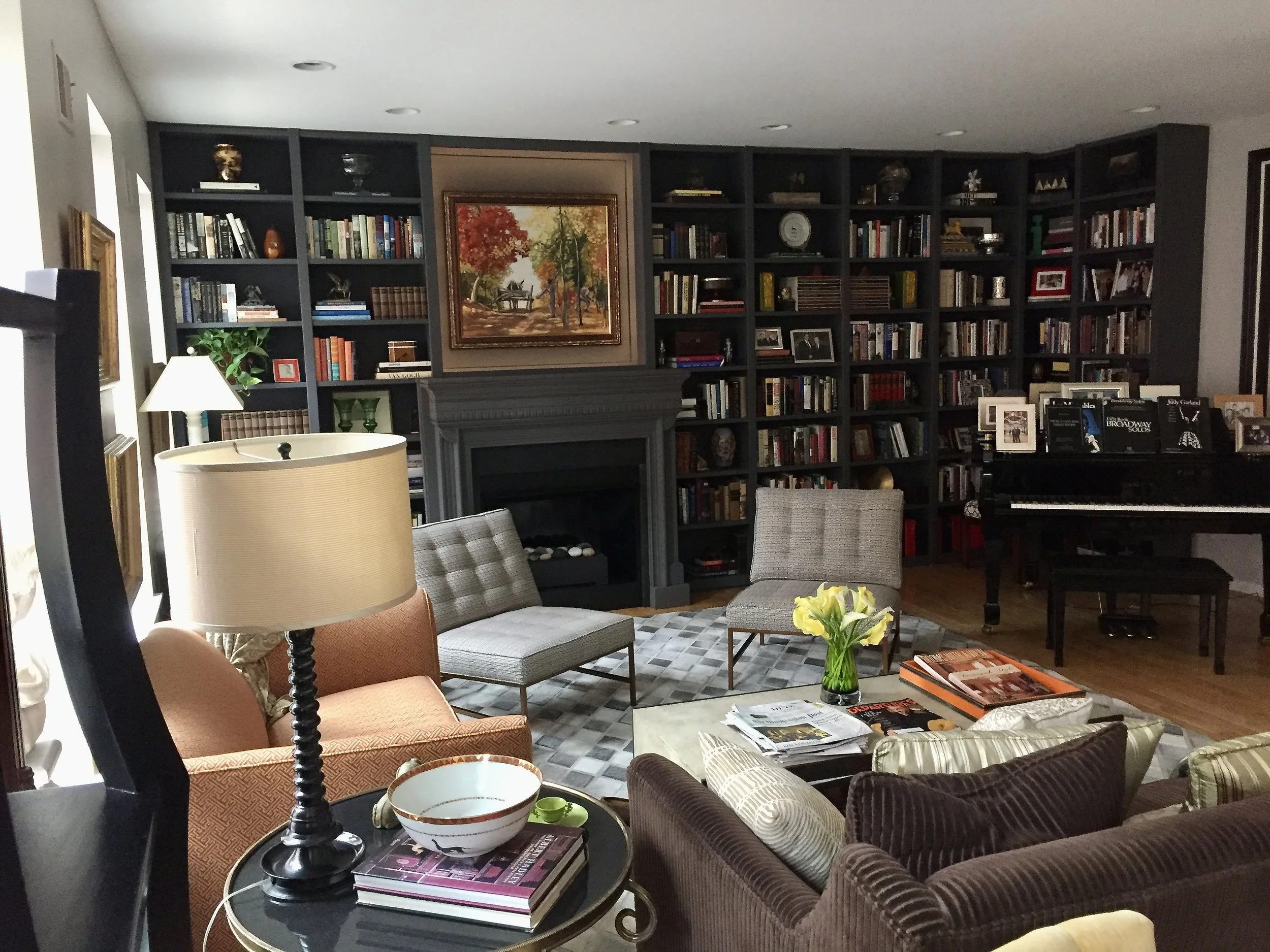 Wall of bookcases around a fireplace with adjoining wall