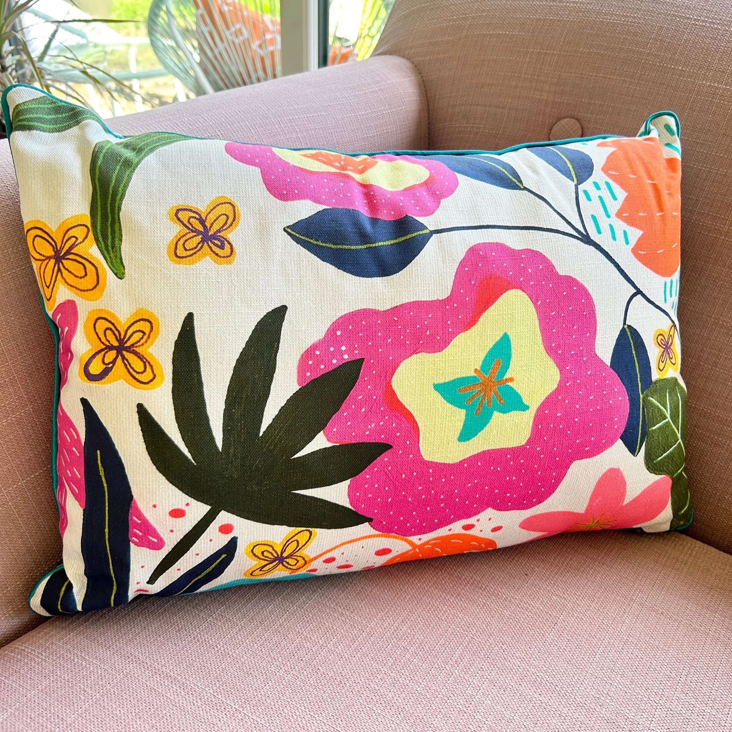 Colourful floral rectangle cushion on a pink linen sofa