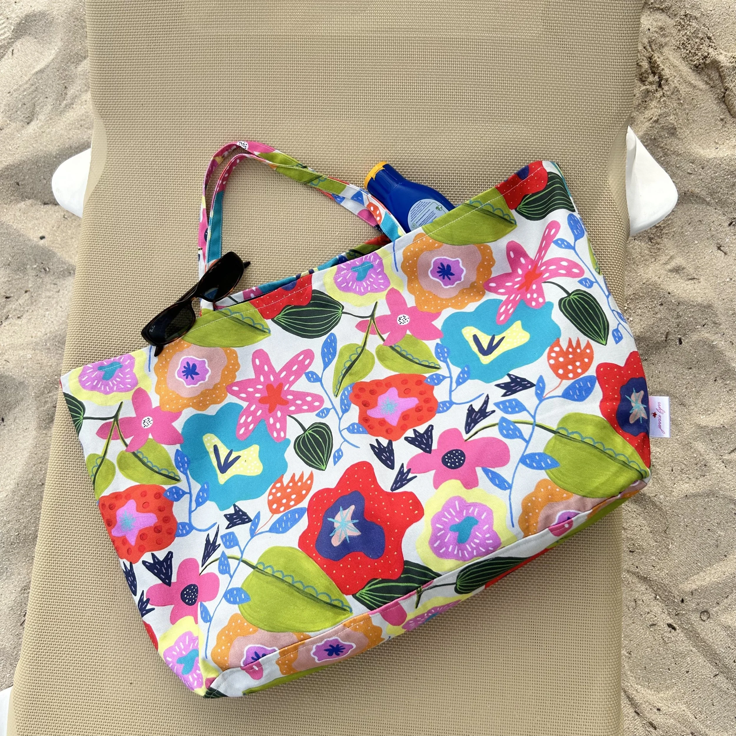 Colourful beach bag on sun lounger