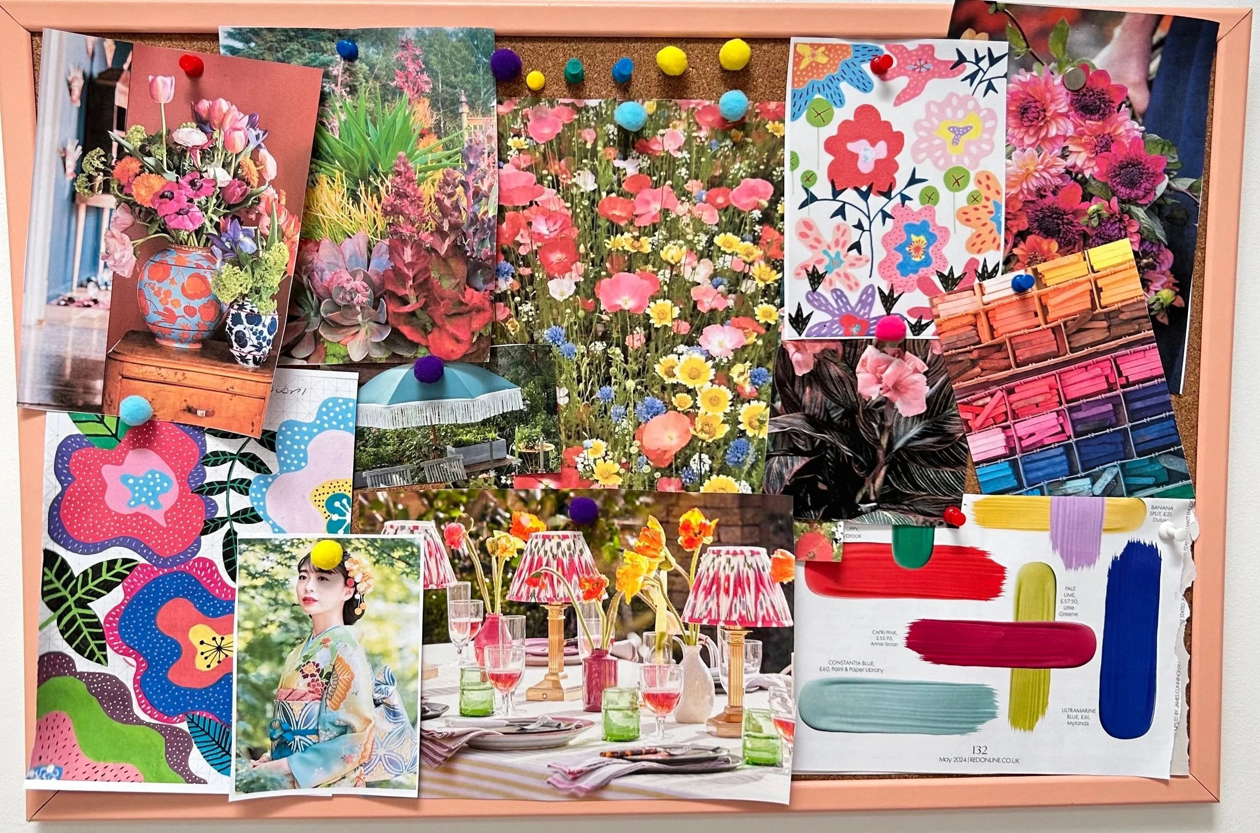Cork board used as a colourful mood board with photos of flowers, colour charts, postcards and sketches