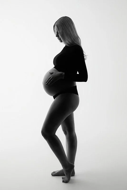 Gravidfotografering i studio svartvitt porträtt