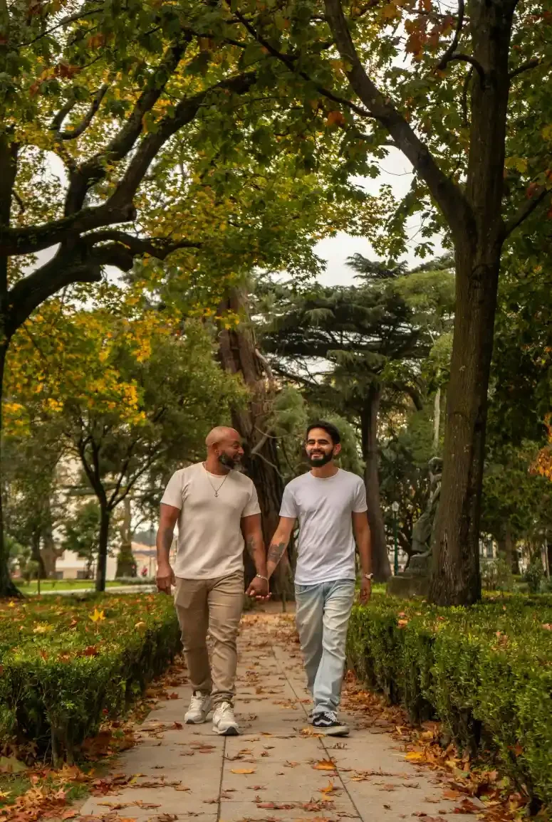 gay couple walking in park holding hands