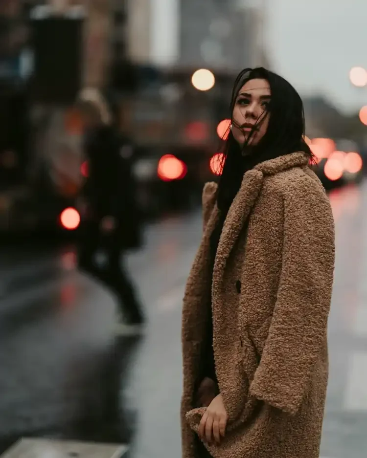 woman in coat staring at the sky