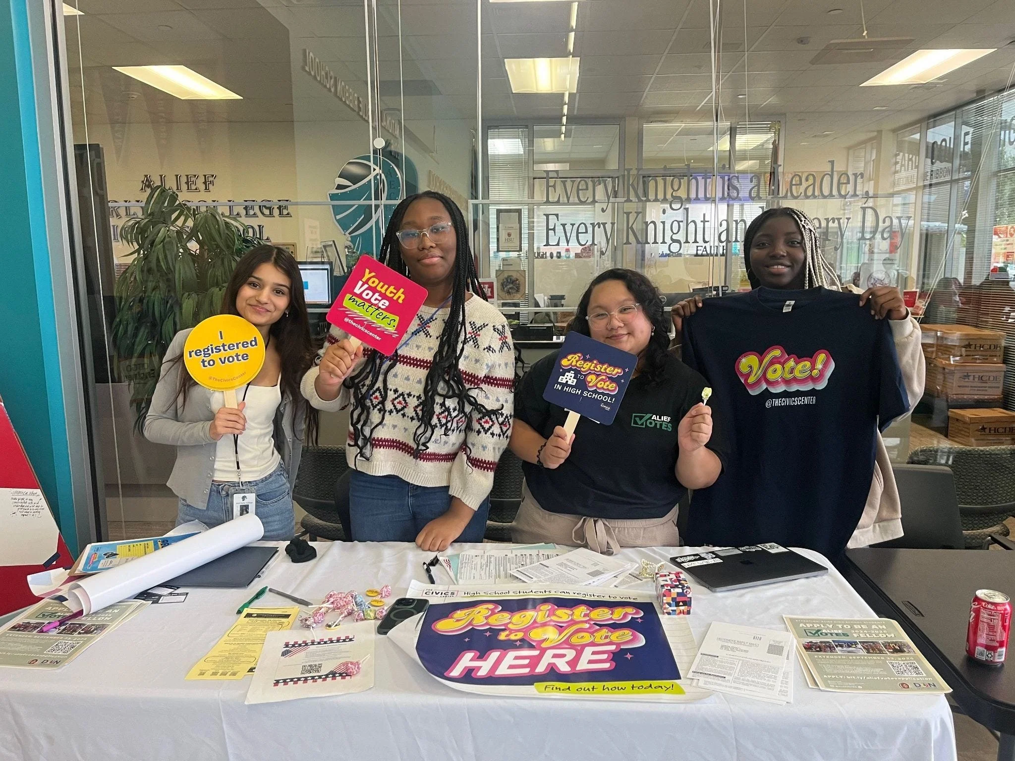 High school students hosting a voter registration table with Cap Gown and Ballot materials.