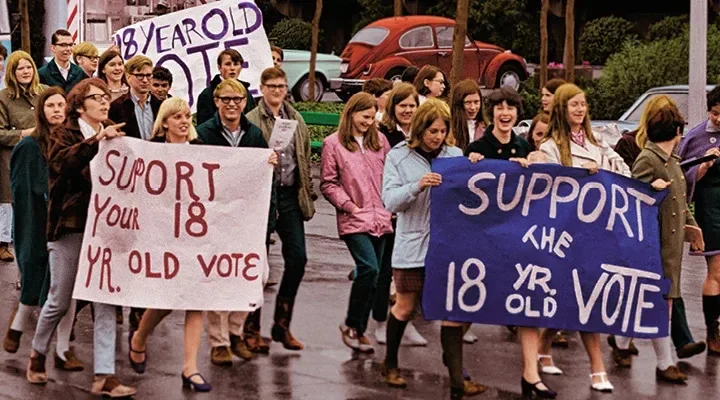 Young people march with signs supporting the 26th Amendment and the right to vote at 18.