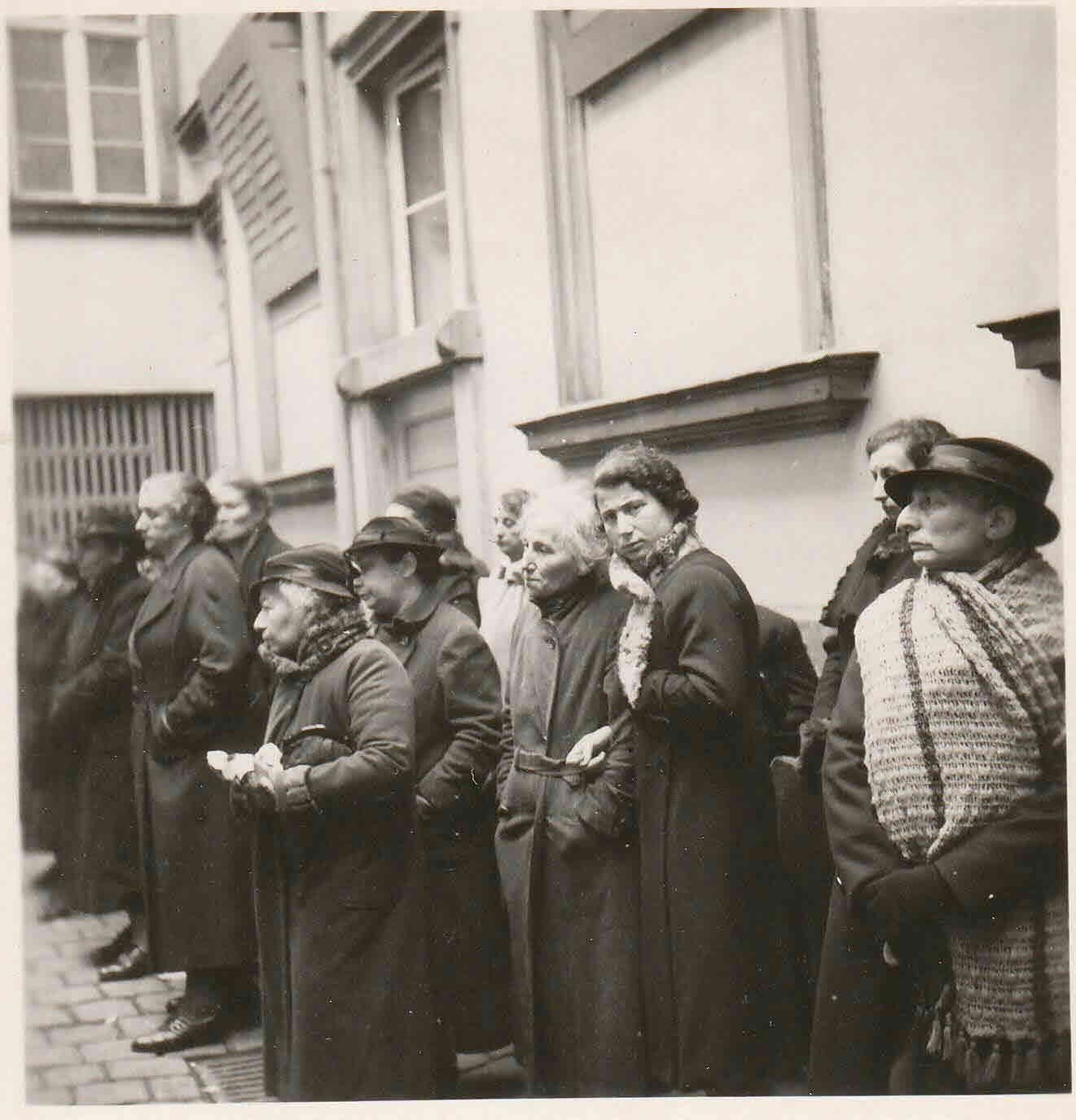 Kathi Brill, Laura W. Brill’s great grandmother, standing with a group of Jewish residents during a roundup, wearing a hat and scarf.