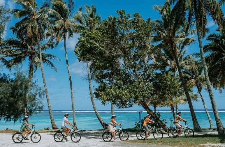 Guests enjoying a Tik-e Tours bike ride along the beautiful coastline of Rarotonga, one of the many activities to enjoy during your stay at Coral Sands Apartments.