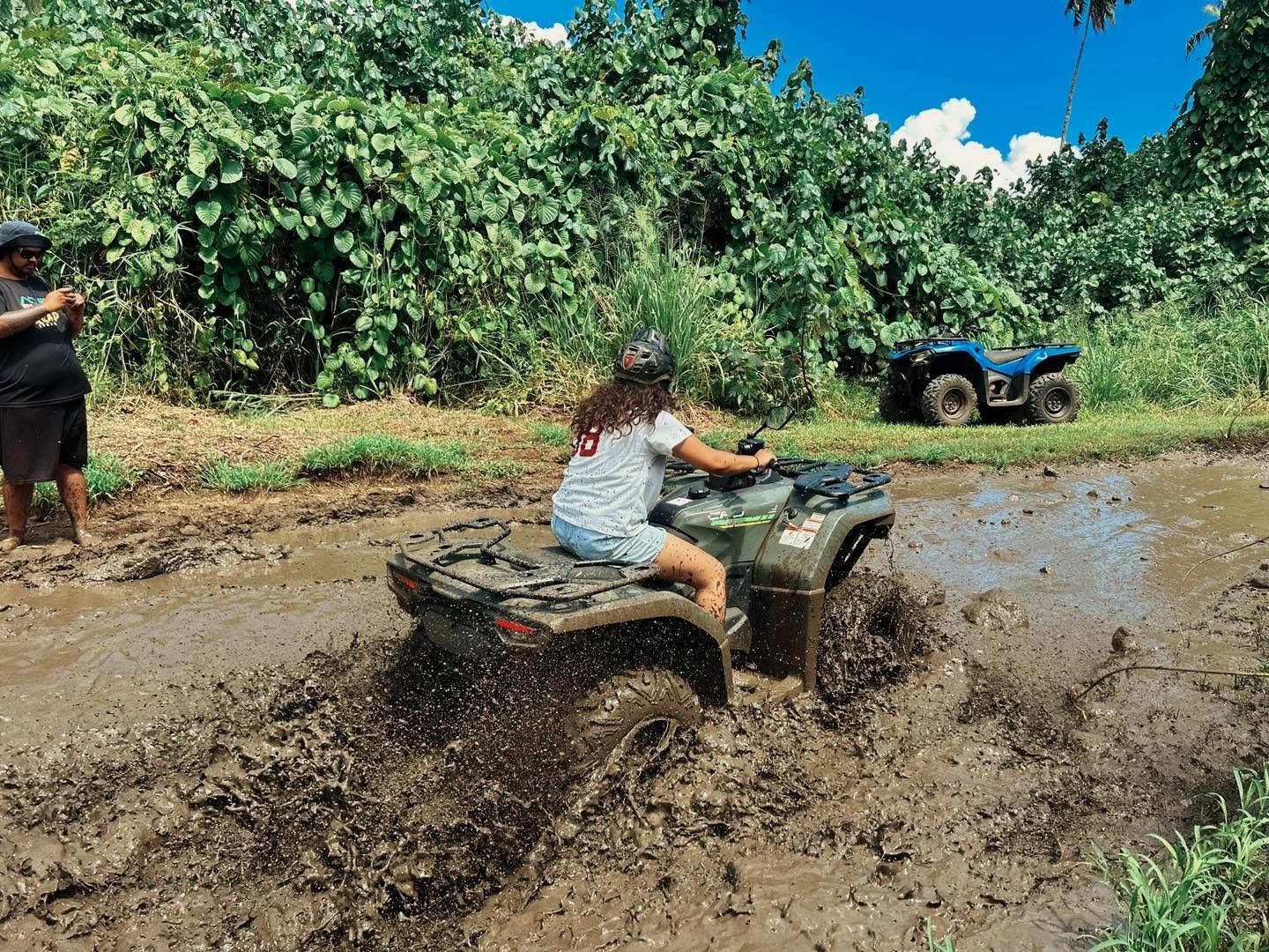 Visitors exploring Rarotonga on a guided quad bike tour through tropical island scenery.