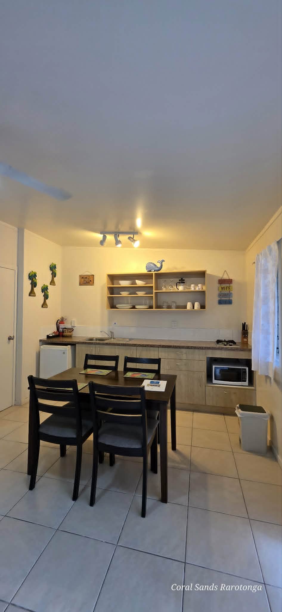 Fully equipped kitchen and dining area in a One Bedroom Courtyard Apartment at Coral Sands Apartments in Arorangi, Rarotonga, with cooking facilities, microwave and self-contained amenities.