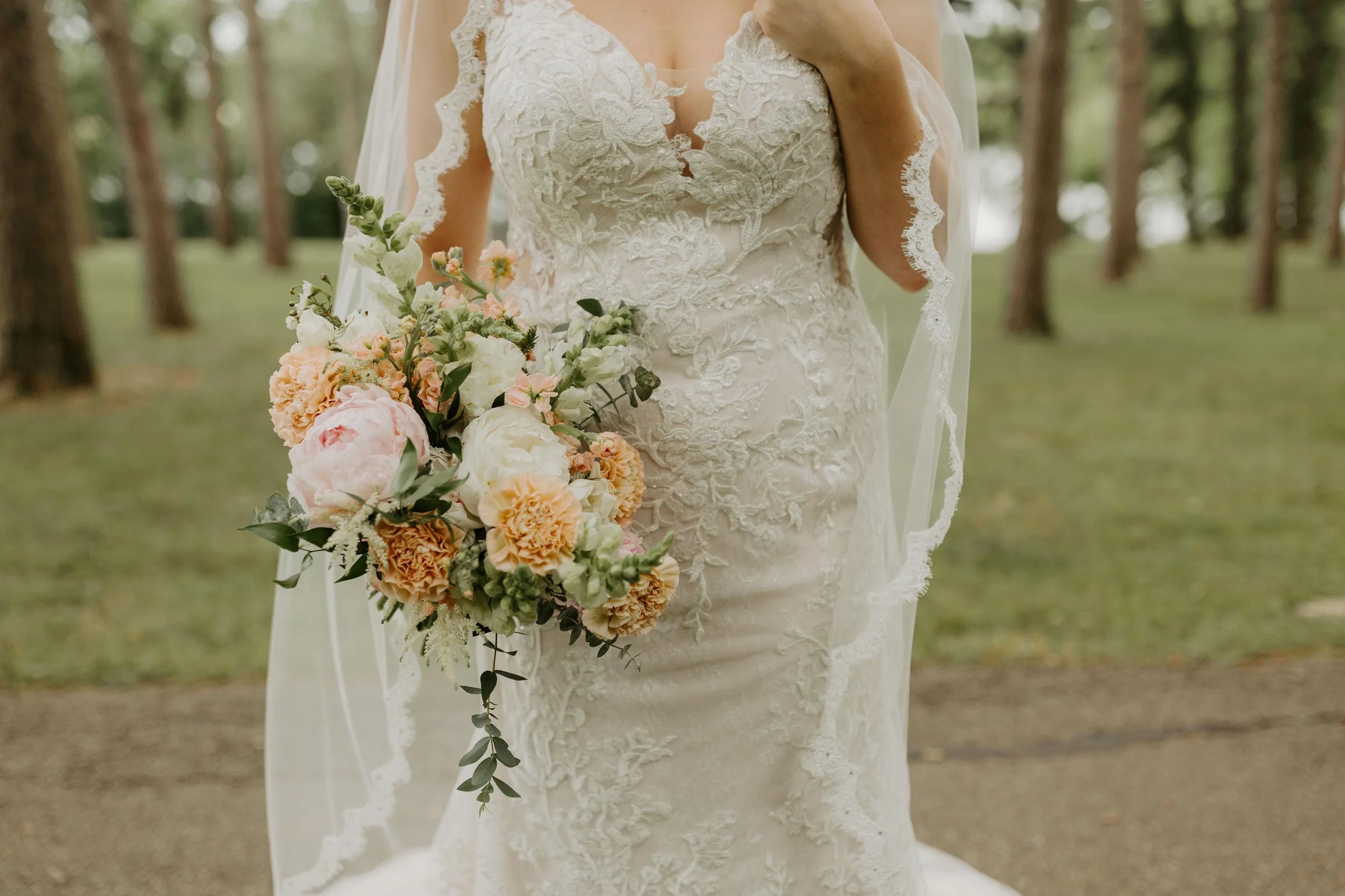 Laurie’s customers, Mariana and Carmen holding hands on a green lawn on their wedding day.