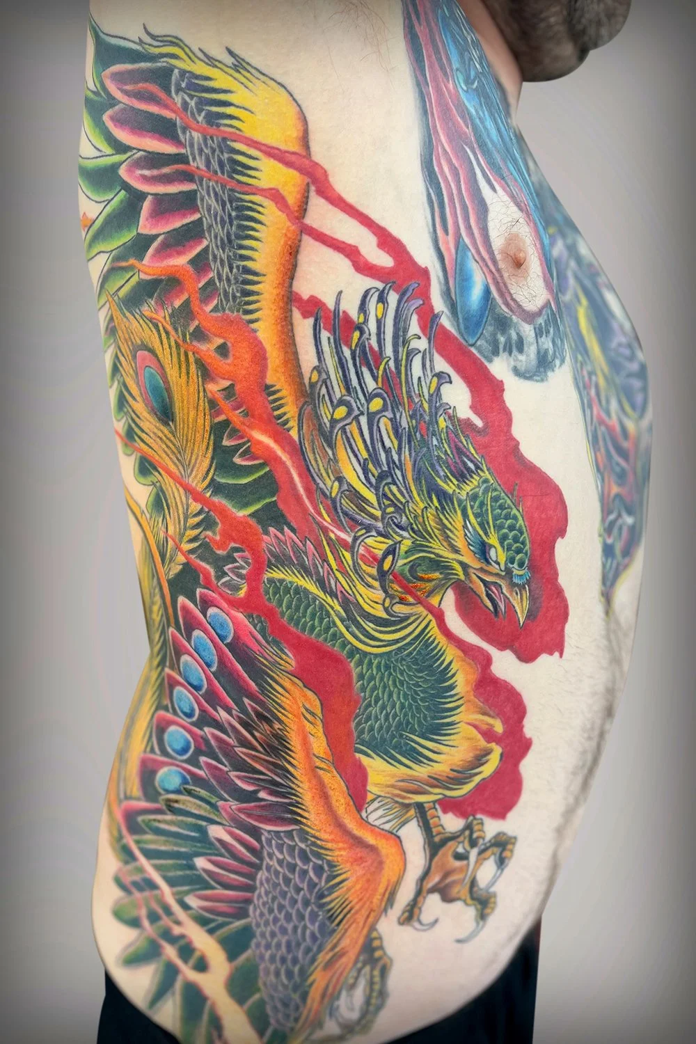 A tattoo spanning the entire rib cage, from just beneath the armpit to the hip bone, slightly wrapping toward the chest and back. 