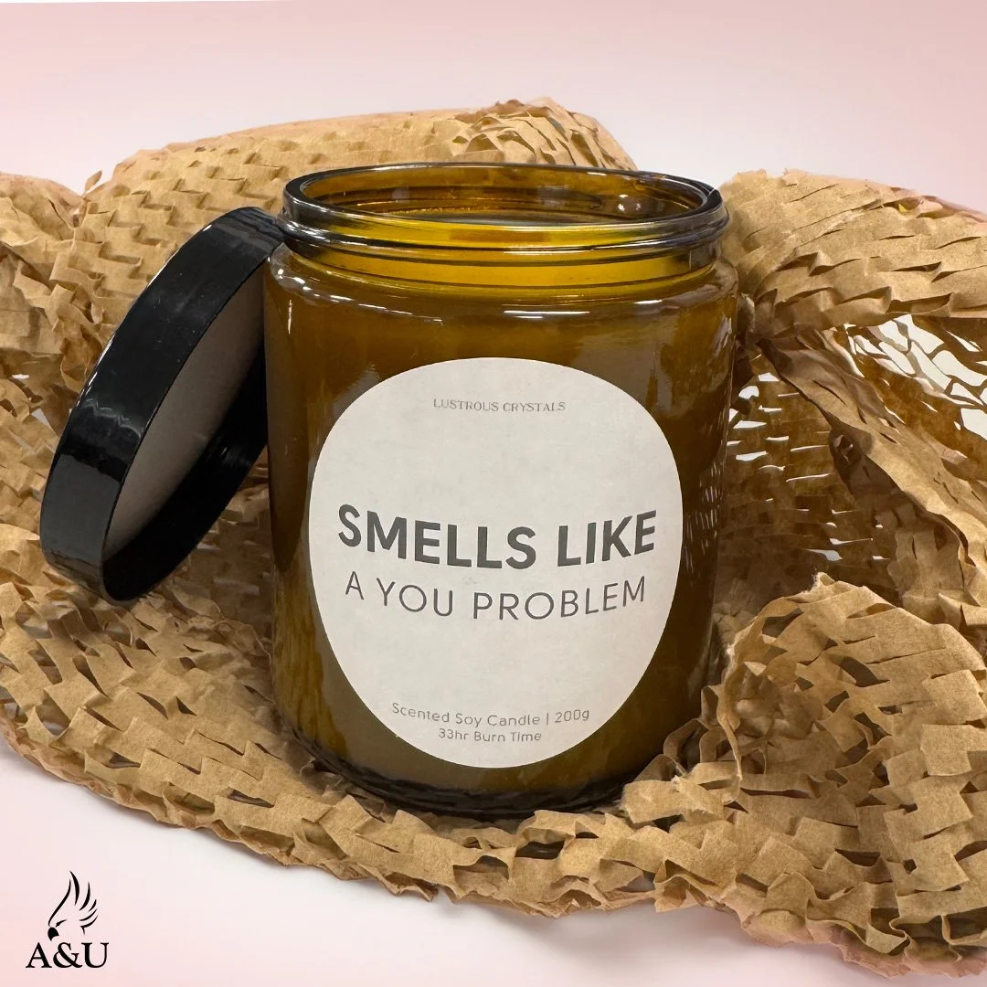 A hand poured candle in a glass jar with a label saying Smells Like A You Problem