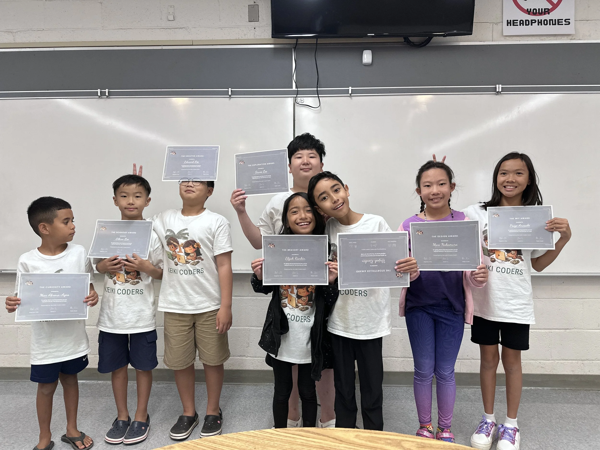 Kids holding coding awards in classroom in Honolulu.
