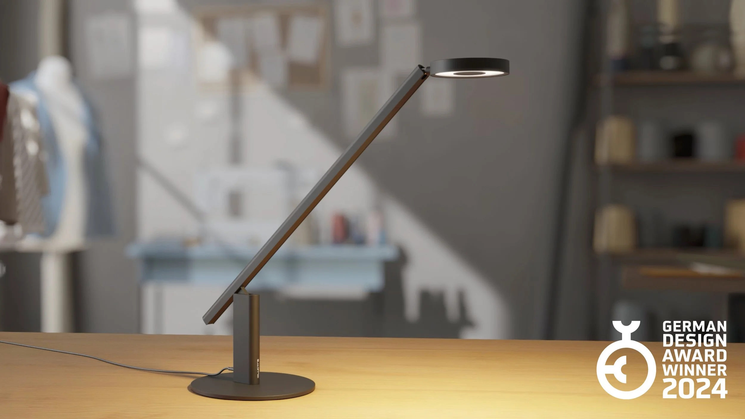 Moderne, schwarze Arbeitsleuchte von LUCTRA auf Holztisch, im Hintergrund unscharfe Regale und bunte Gegenstände, Logos des Deutschen Design Awards 2024.