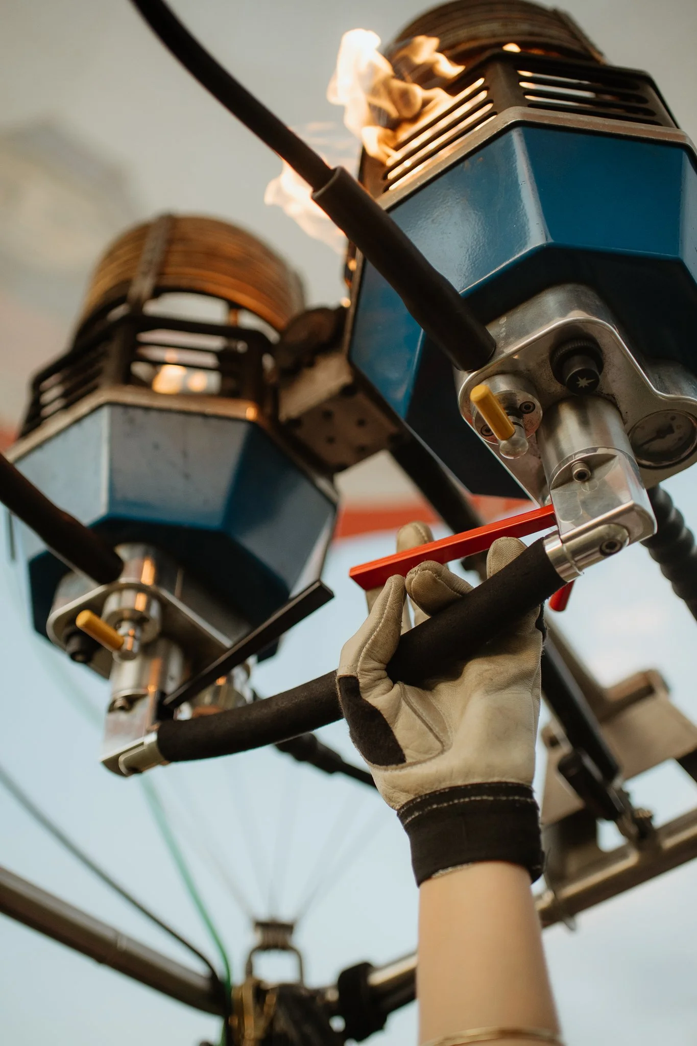 Mitarbeiter trägt Handschuhe und arbeitet an einem mechanischen Gerät mit blauen Gehäusen, das auf einem großen Rad oder Rotor montiert ist.