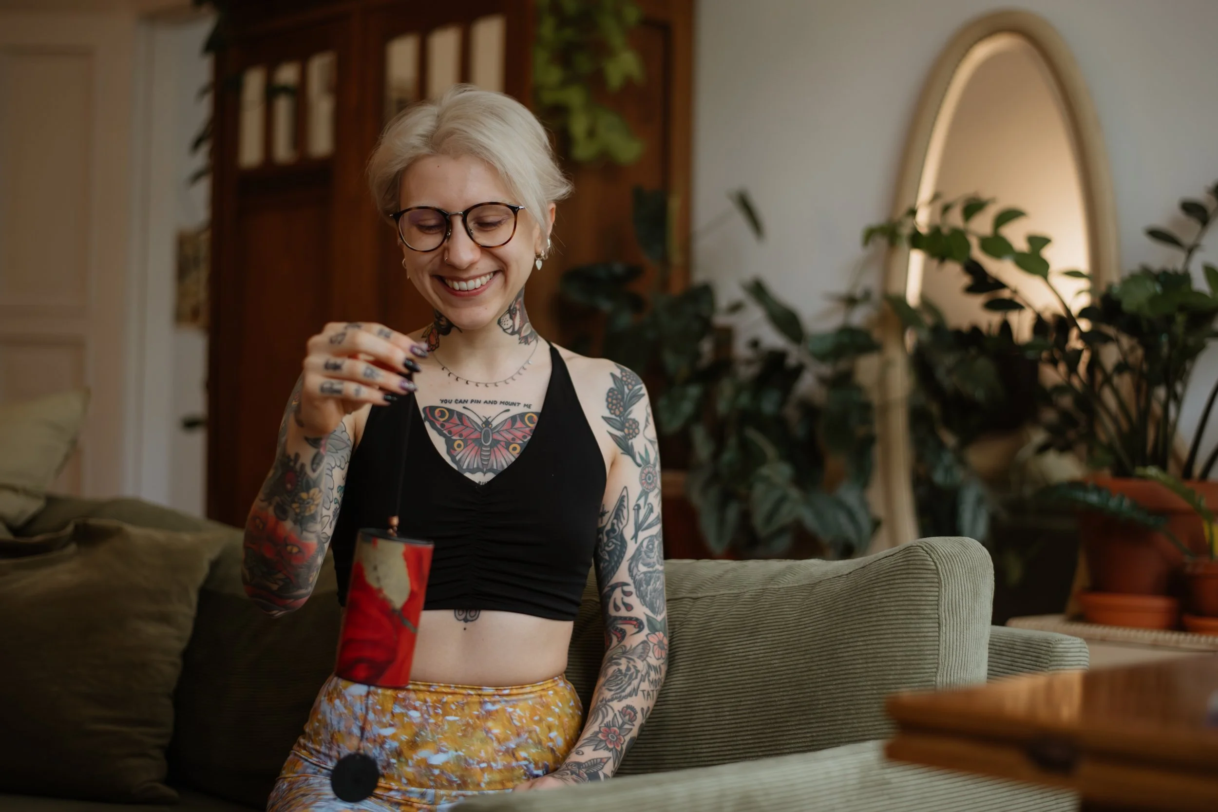 Lächelnde Frau mit Brille zündet Kerze an – Lifestylefotografie Yoga Studio Berlin
