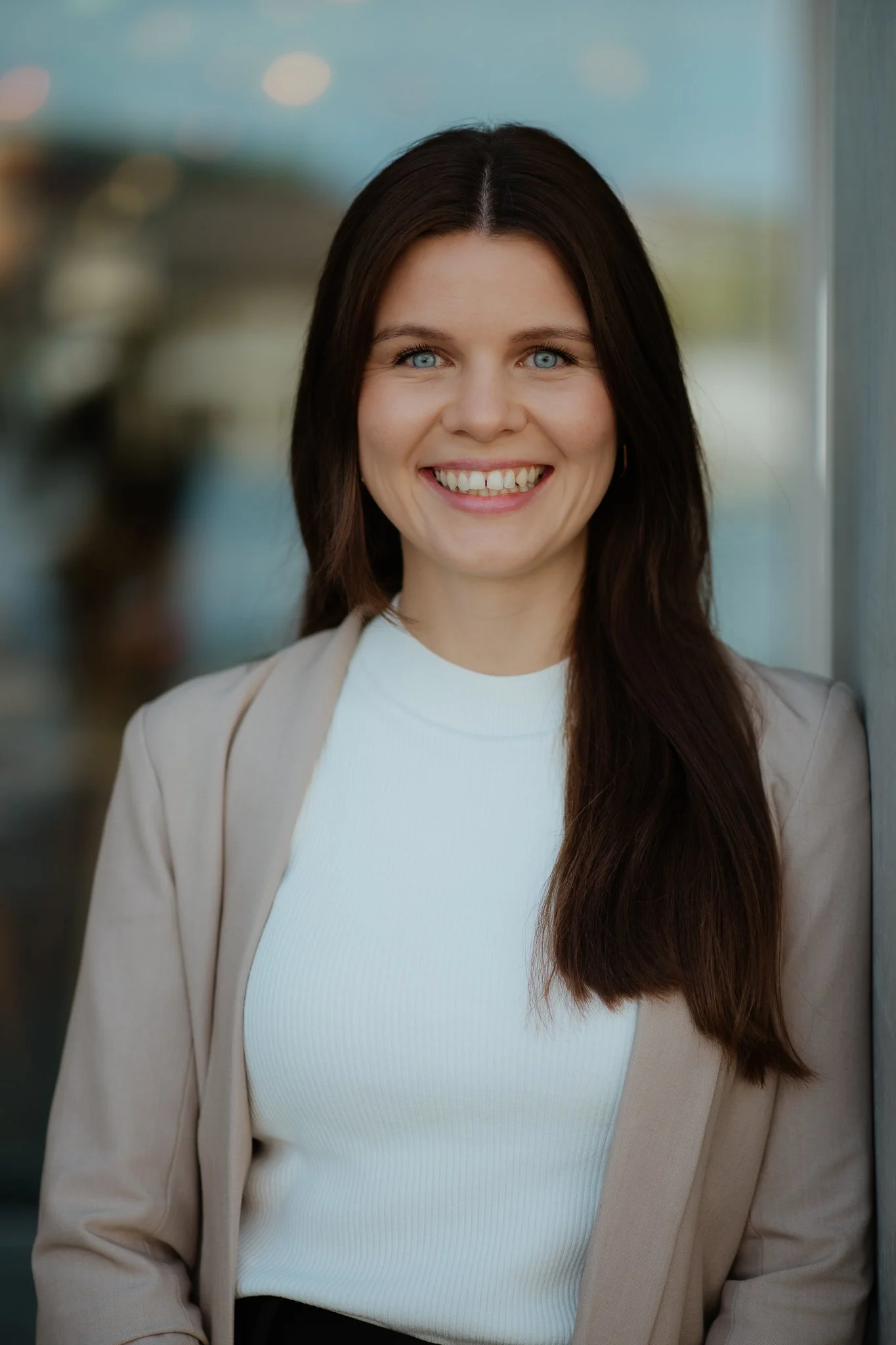Junge Frau vor Fenster mit Bluse und Blazer – Business Portraitfotografie Berlin
