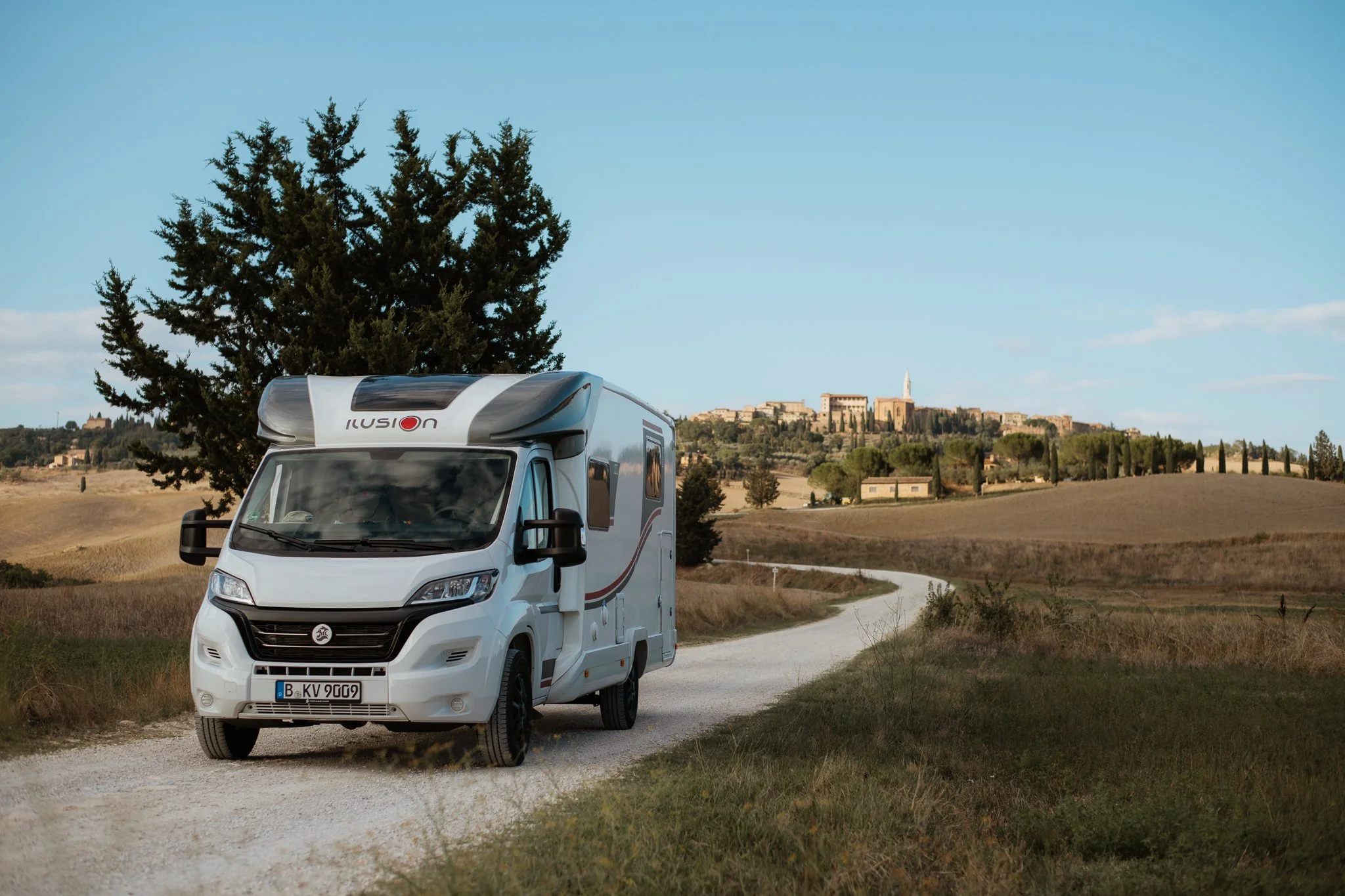 Weißes Wohnmobil auf Landstraße mit Hügeln – Reisefotografie Camper Lifestyle