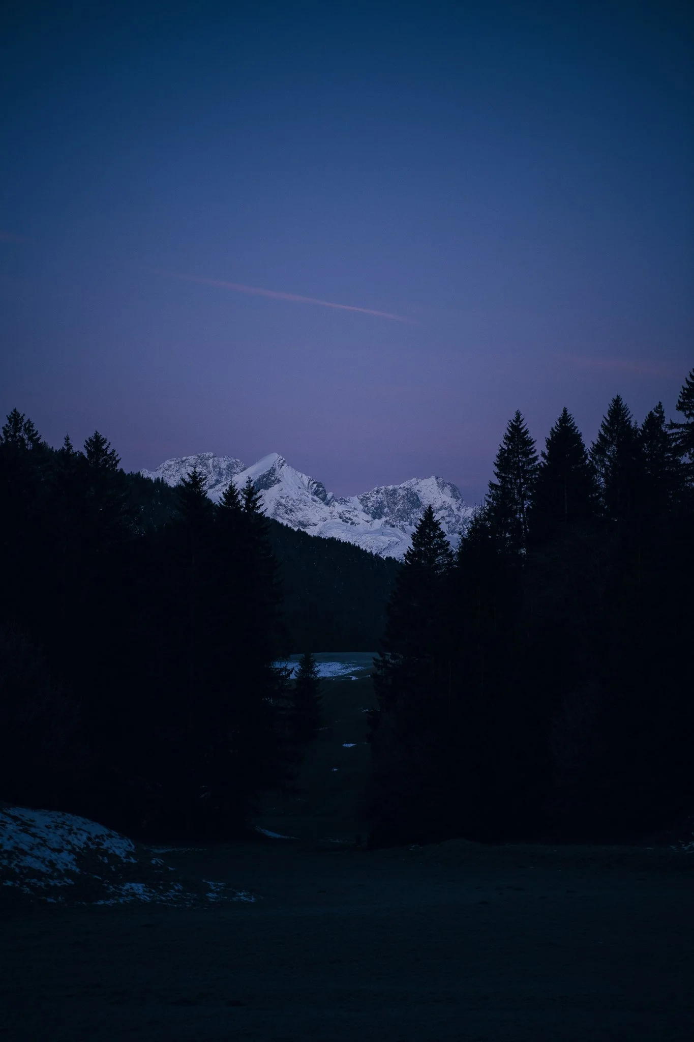 Schneebedeckte Bergkette bei Nacht mit Tannen – Reisefotografie Alpen
