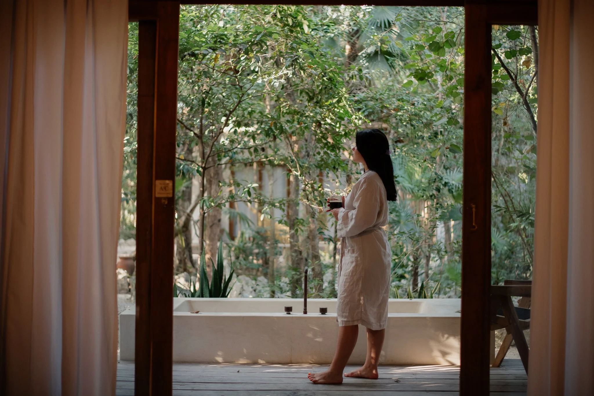 Frau im Bademantel trinkt Kaffee auf Terrasse – Lifestylefotografie Berlin Tourismus
