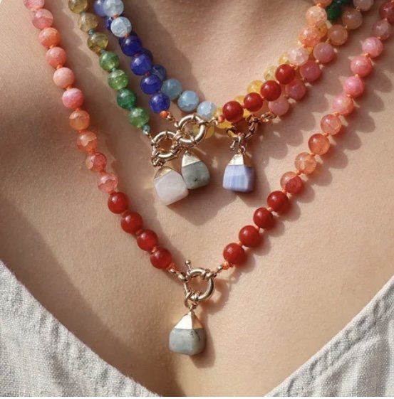 Frauenhals mit mehreren bunten Halbedelsteinketten