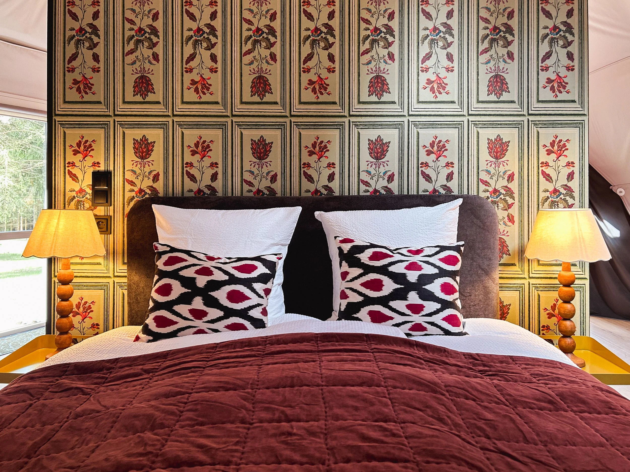 Cozy double bed inside a luxury glamping dome, featuring soft linens