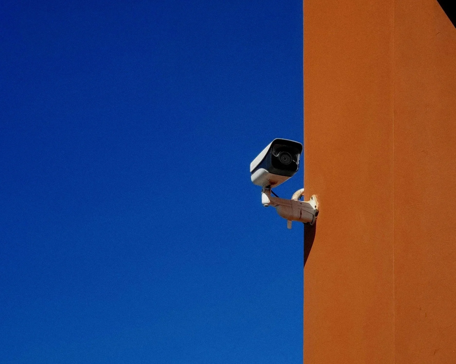 Alex Fix Servizi di Video sorveglianza Telecamera di sorveglianza installata su un muro arancione e blu