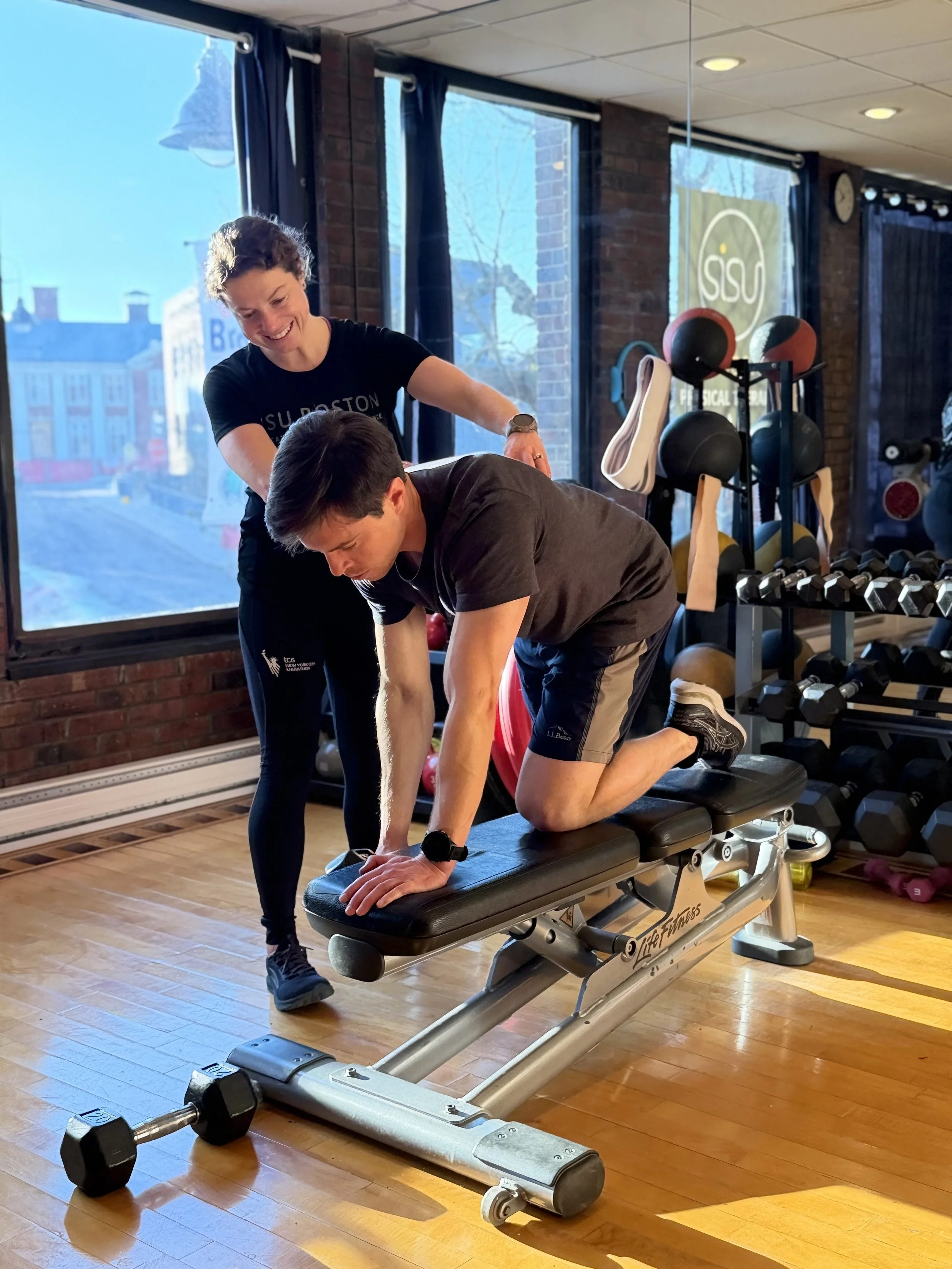 Sisu Boston in Brookline physical therapist works with athlete doing bent over row.
