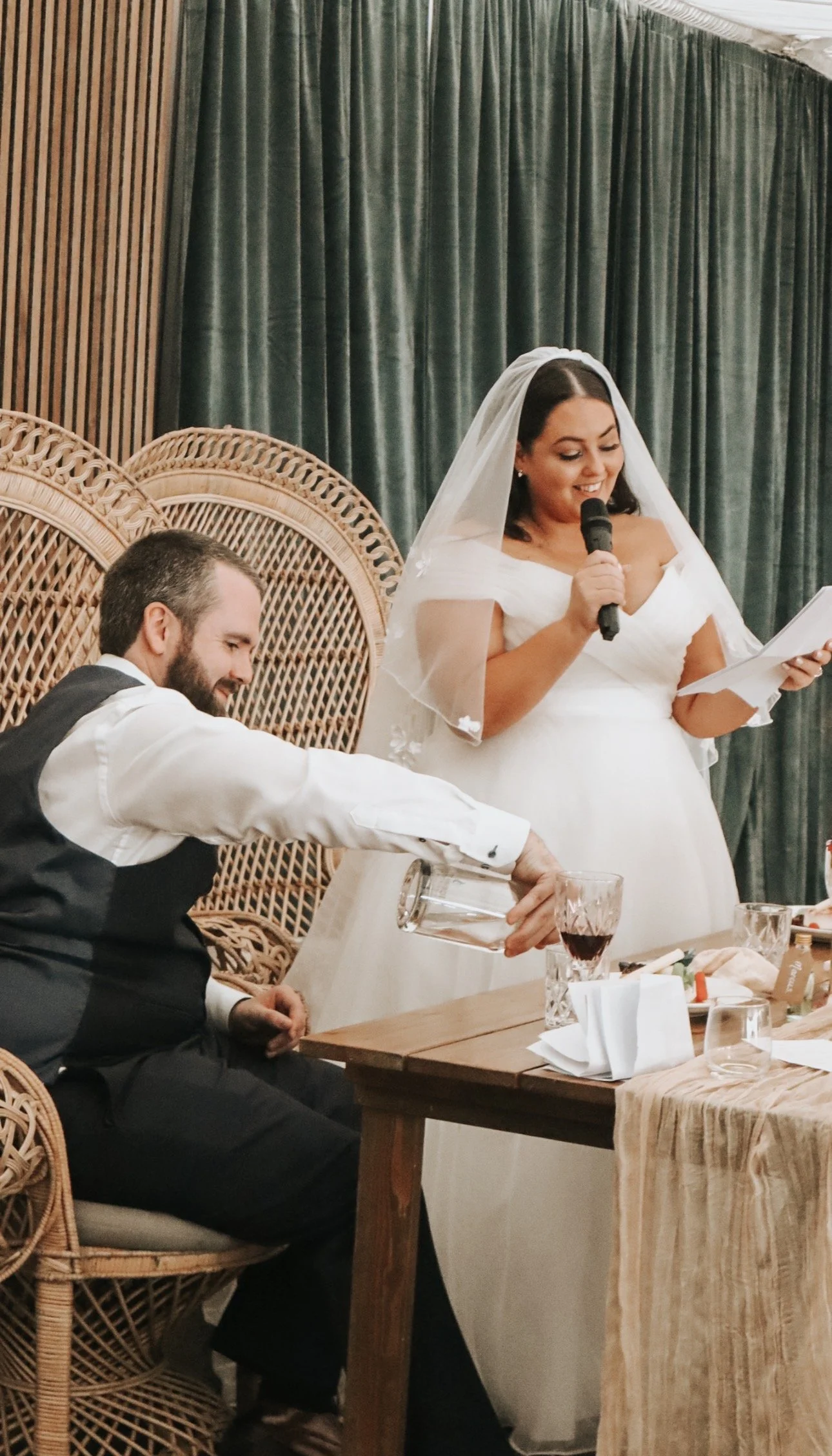 Bride reading a toast with a microphone while groom pours wine at a wedding reception in Mountain View Kilkenny, Wedding venue. Wedding Content Creator Ireland 