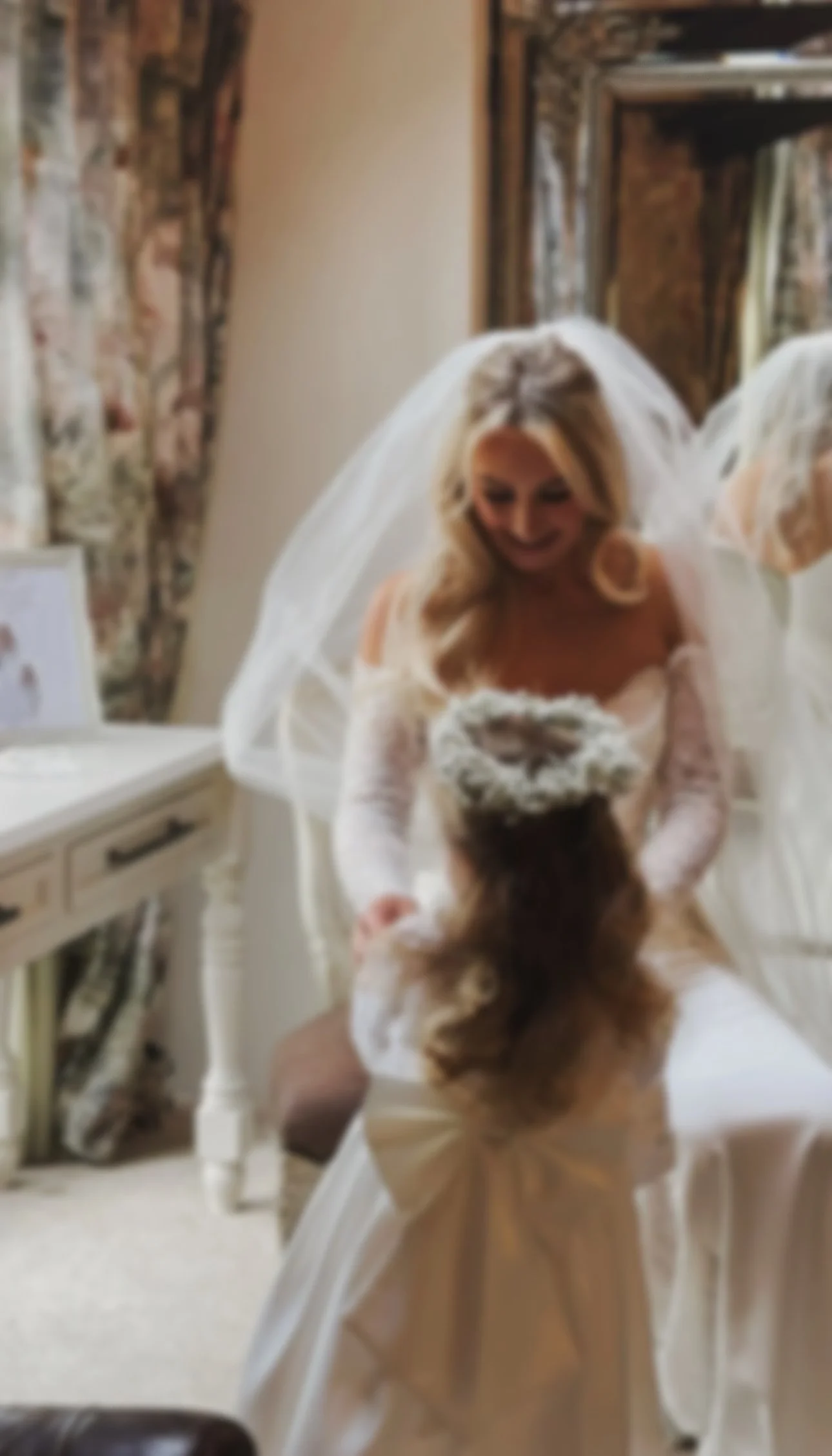 A bride & flower girl getting ready in Ballymagarvey Village Co. Meath, Wedding Venue. Candid moment of the Bride looking down at the flower girl captured by their wedding content creator